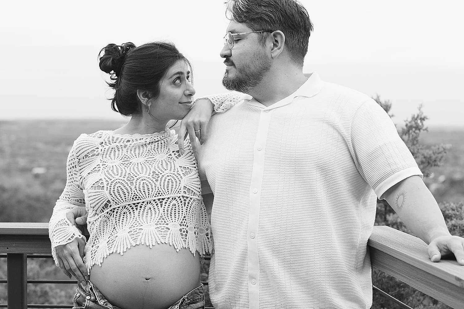  couple embraces on deck overlooking Teas hill country by Austin maternity photographer 