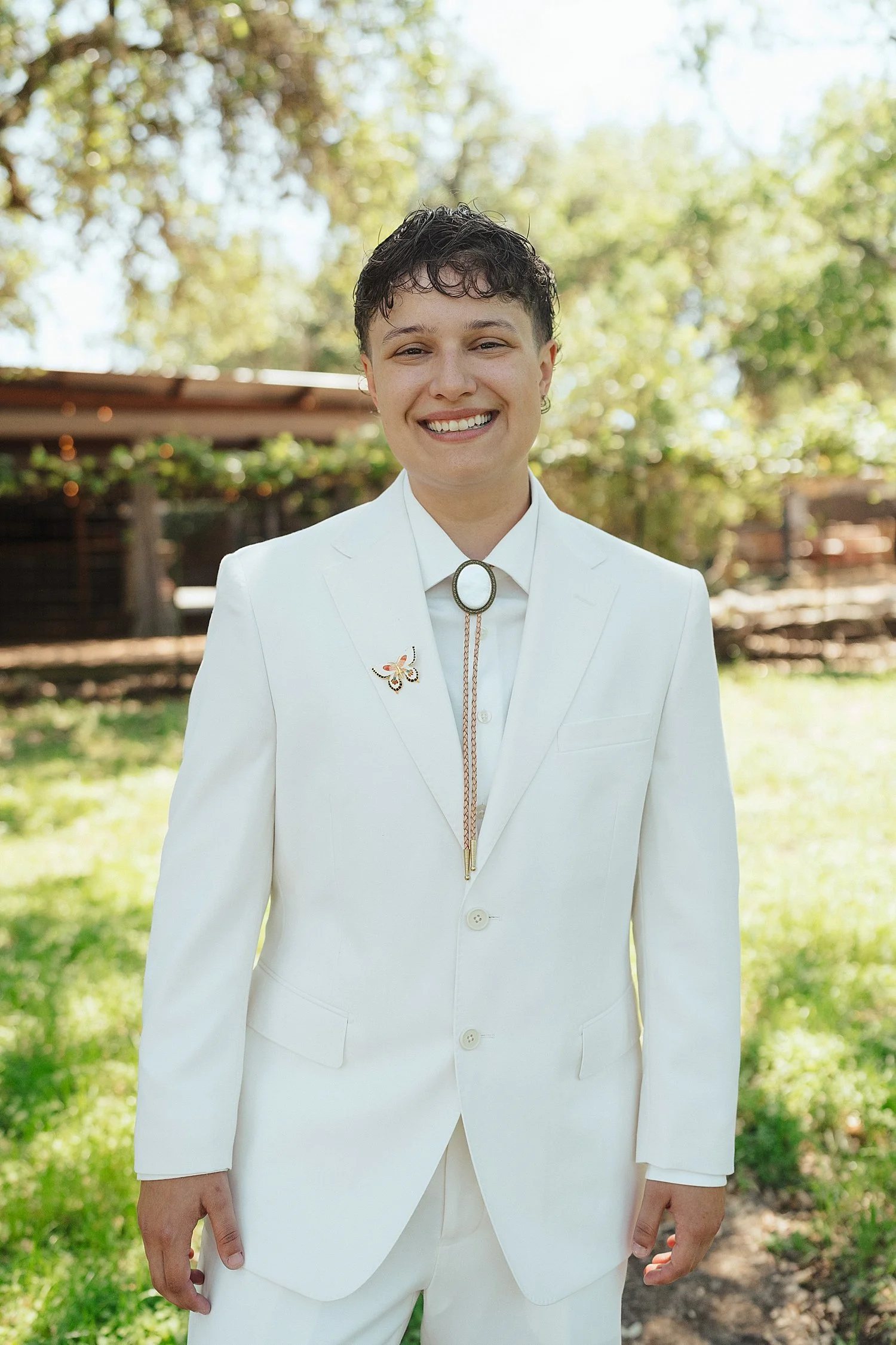  bride in white suit and bolo tie on lawn by Jessica Joseph Photography 