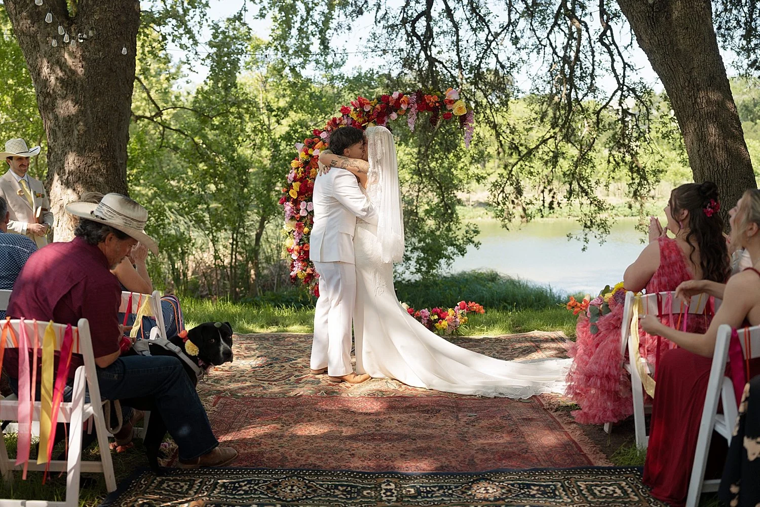  newlyweds share a kiss at floral alter at colorful wedding celebration 