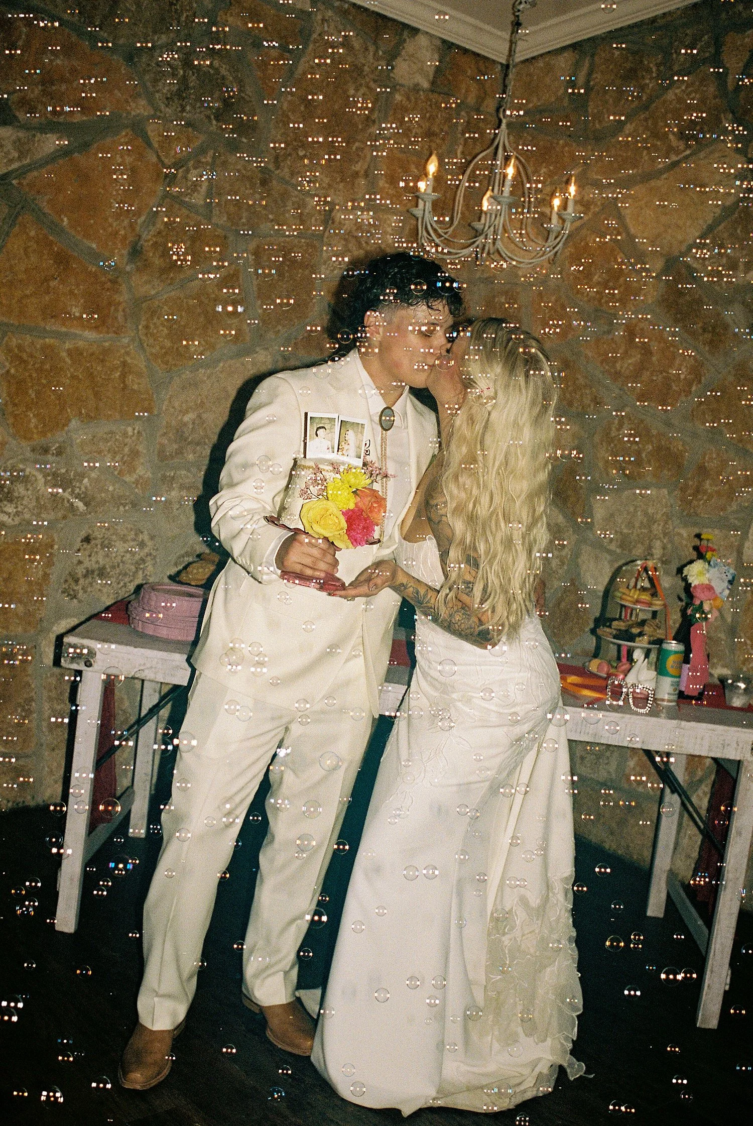  brides share a kiss at the end of the night for colorful wedding celebration 