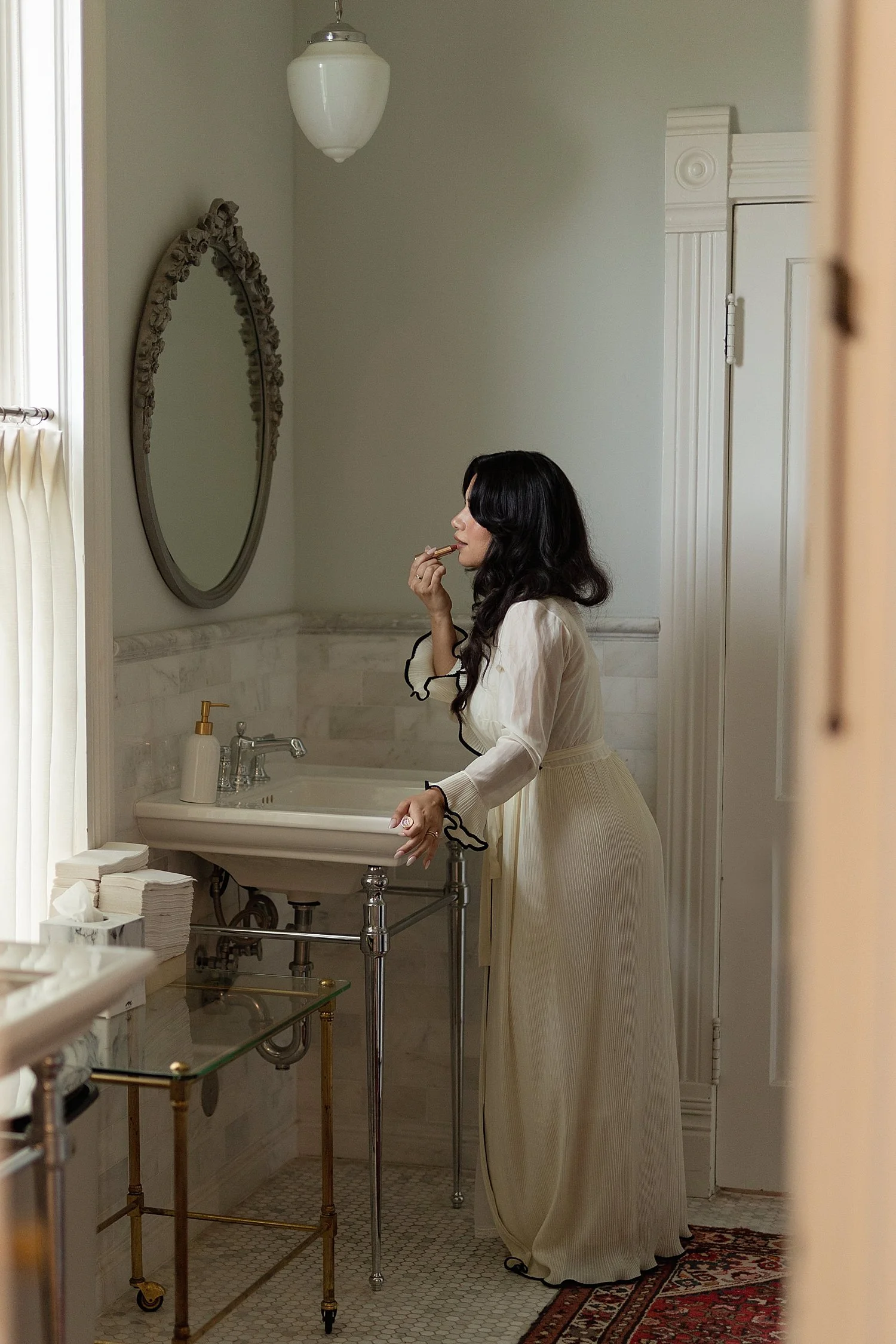  bride gets ready looking in circle mirror at Woodbine Mansion 