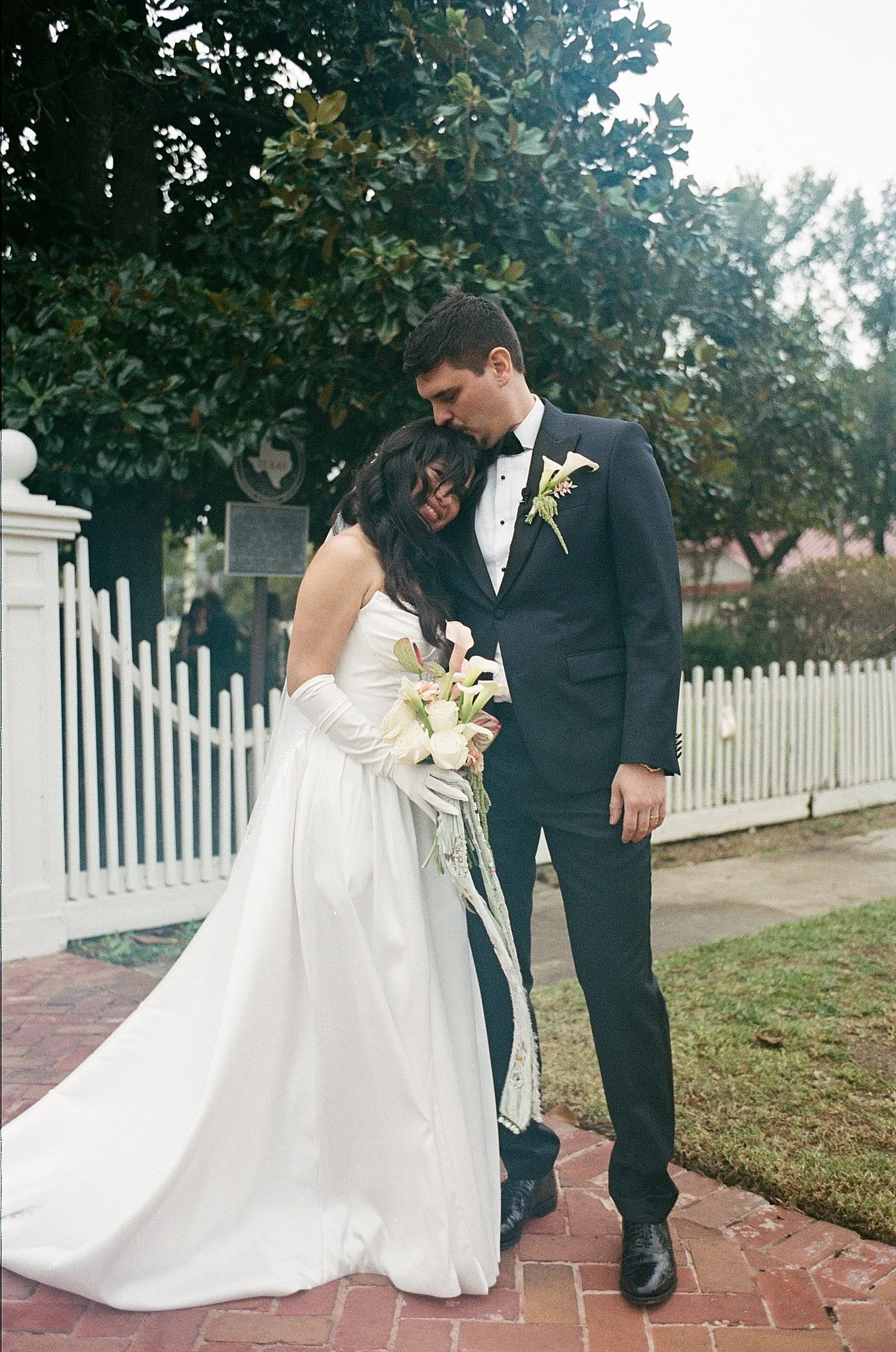  couple snuggle on sidewalk after saying I do at Woodbine Mansion 
