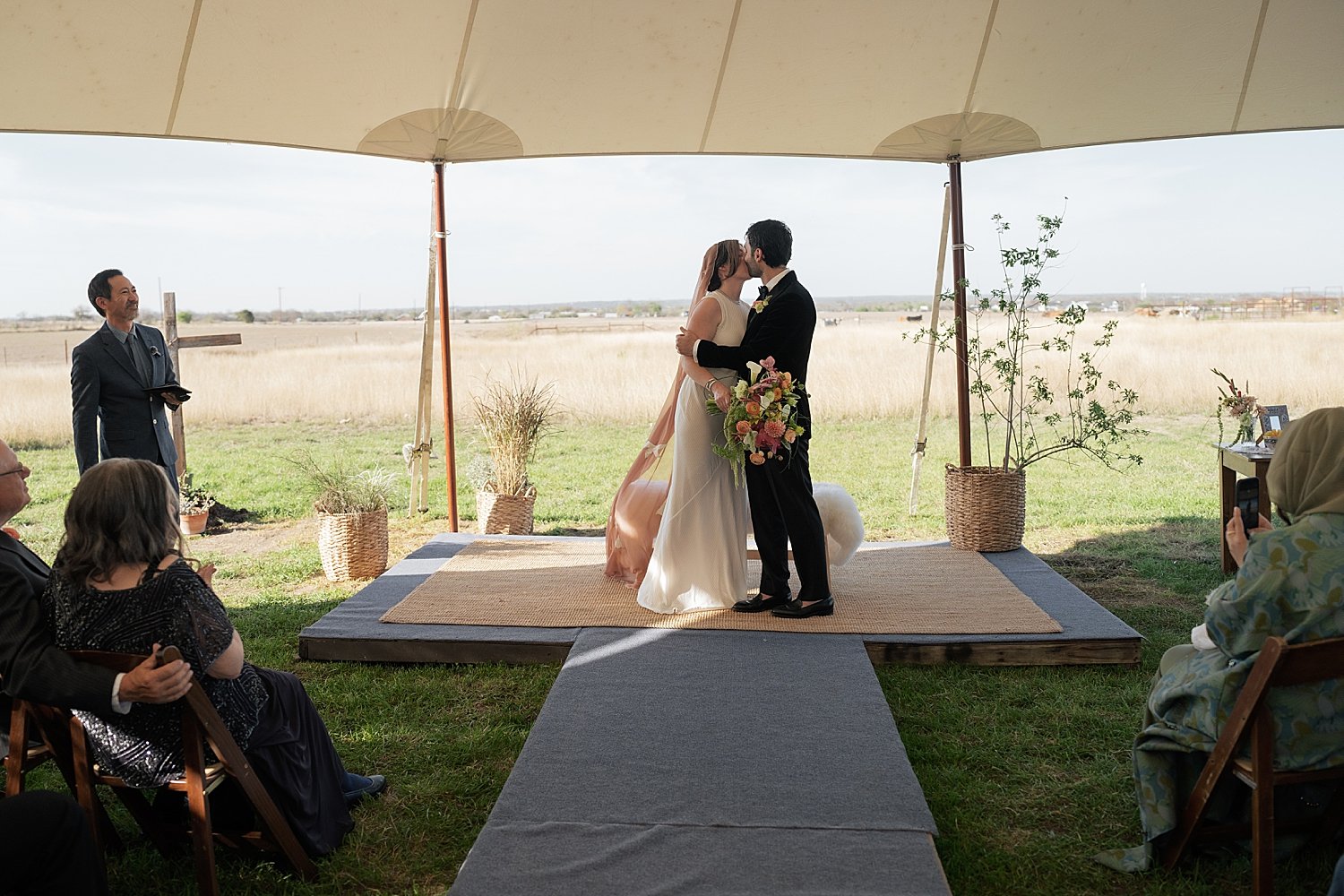  husband and wife share first kiss at outdoor ceremony by Austin photographer 