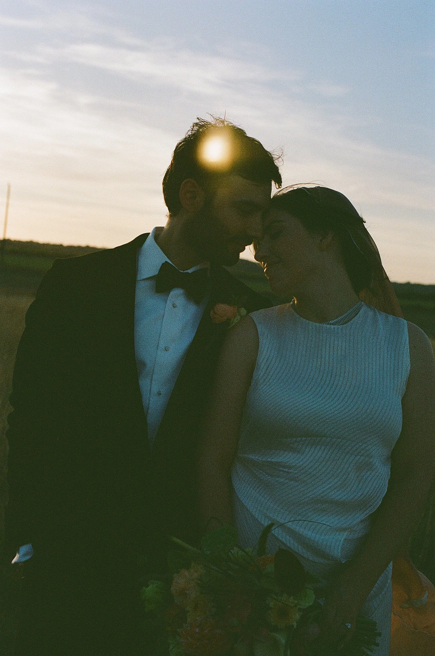  newlyweds snuggle under golden hour light for backyard wedding in Texas Hill Country 