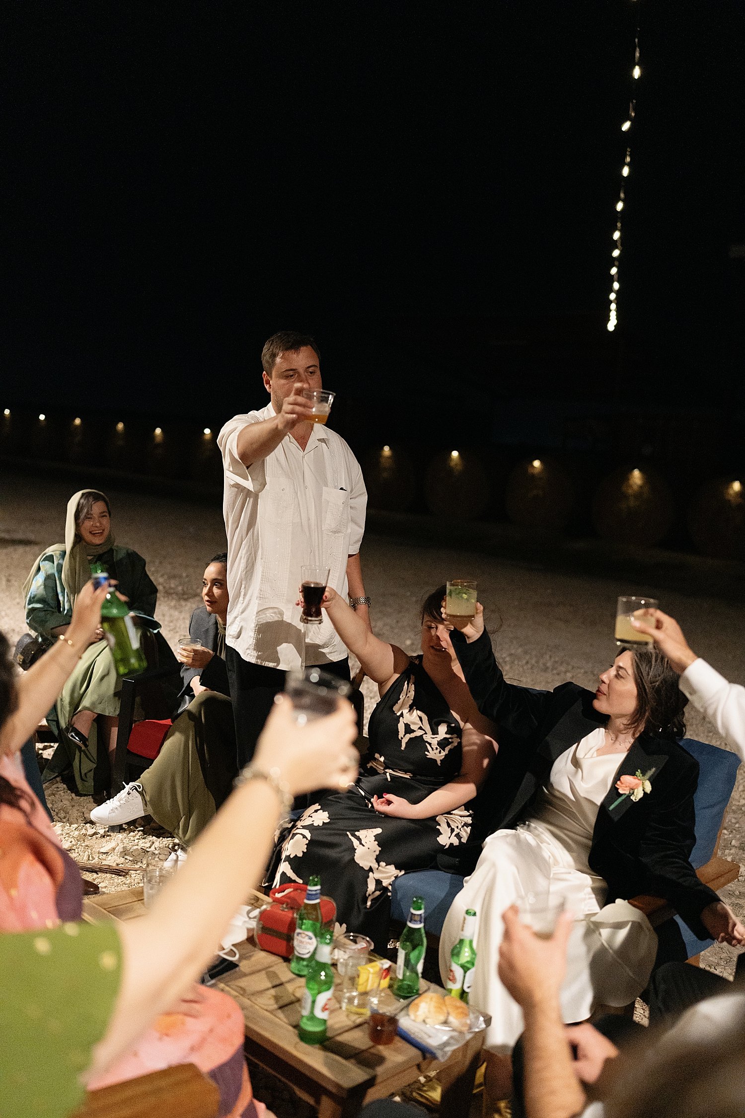  guests raise a toast outside around firepit by Jessica Joseph Photography 