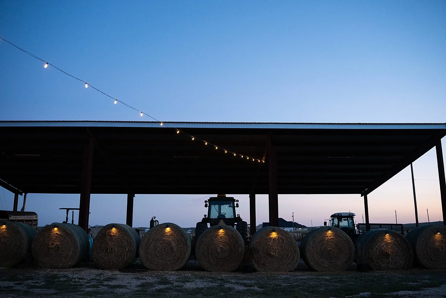  barn at sunset with tractor out front at backyard wedding in Texas Hill Country 
