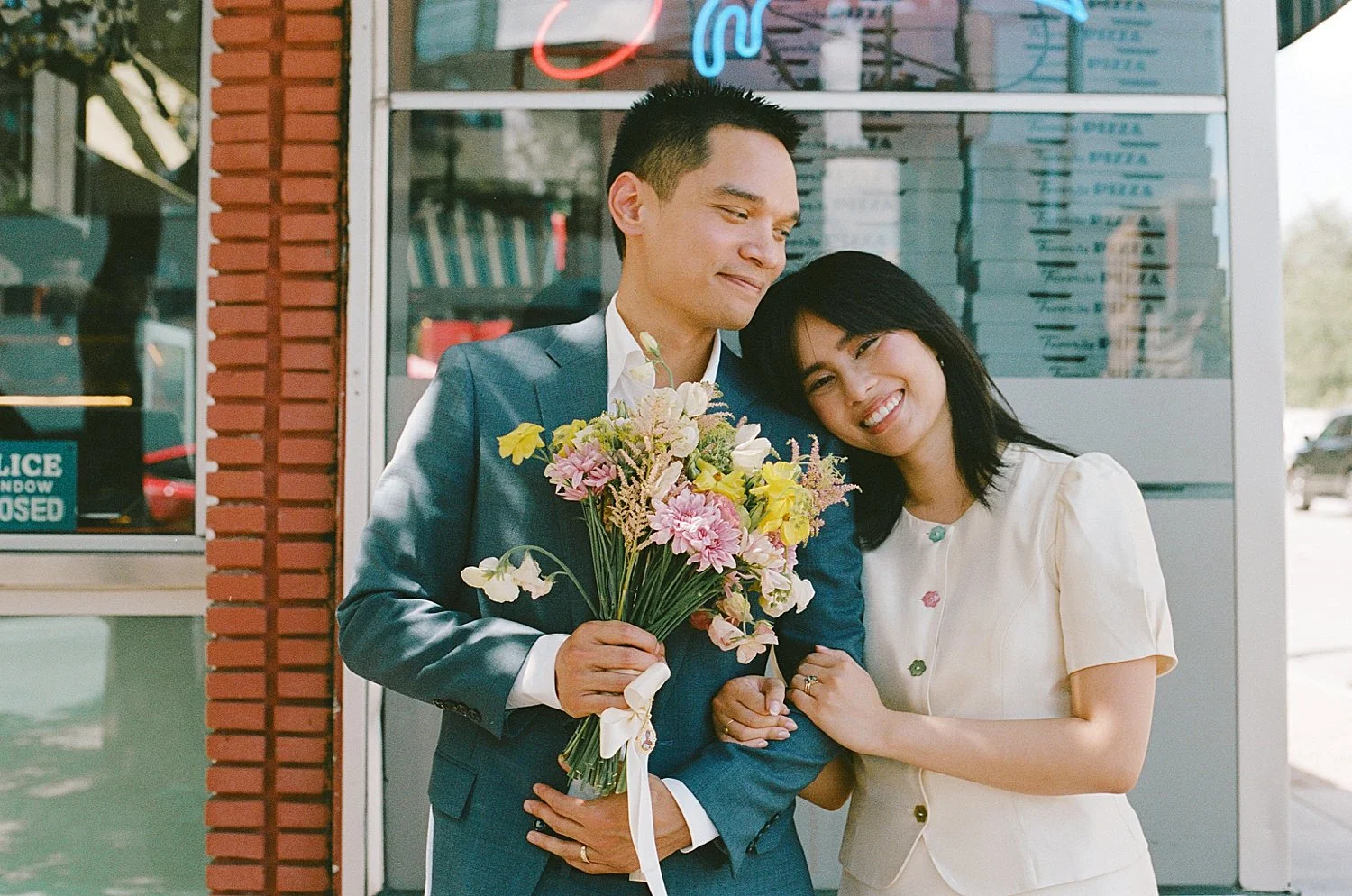  couple snuggle outside pizza place for a quintessential Austin elopement 