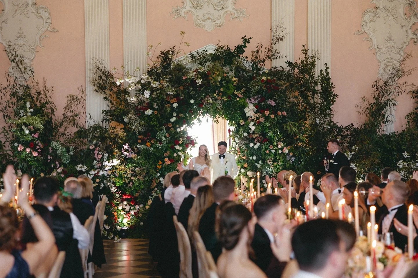 The Ragley Hall Ballroom was transformed from ceremony to dinner with sleek precision. 

3 long tables were adorned with a mixture of sunset-inspired floral hues, textured tableware, and an abundance of candles. 

Guests sat on tables named after 3 s