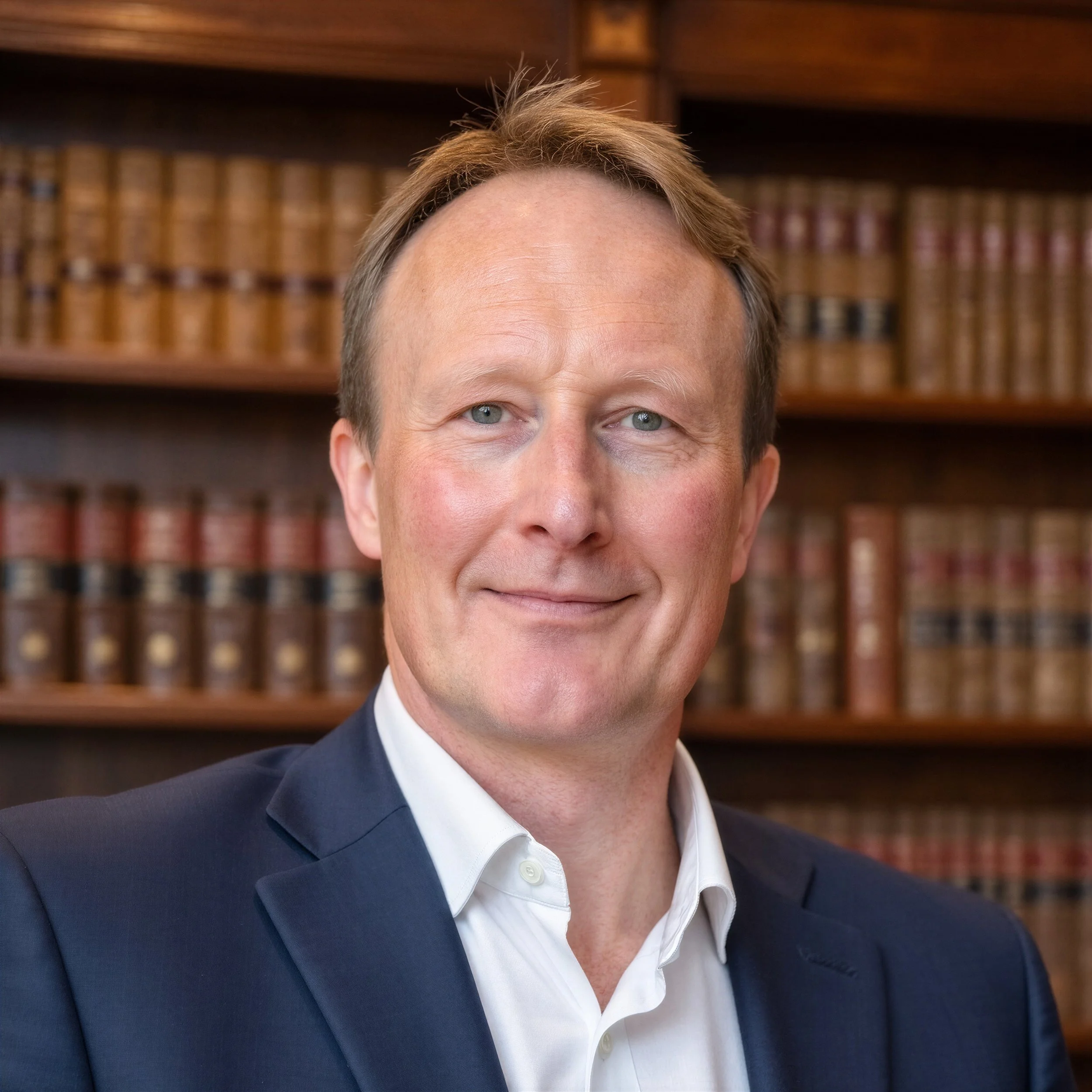 Professional headshot of an energy industry executive against a library backdrop.