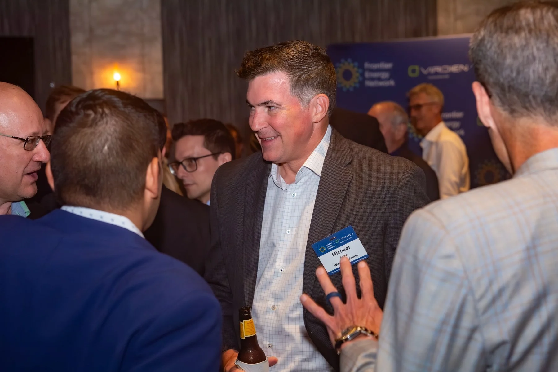 Executives engaging in conversation at a Frontier Energy Network reception.