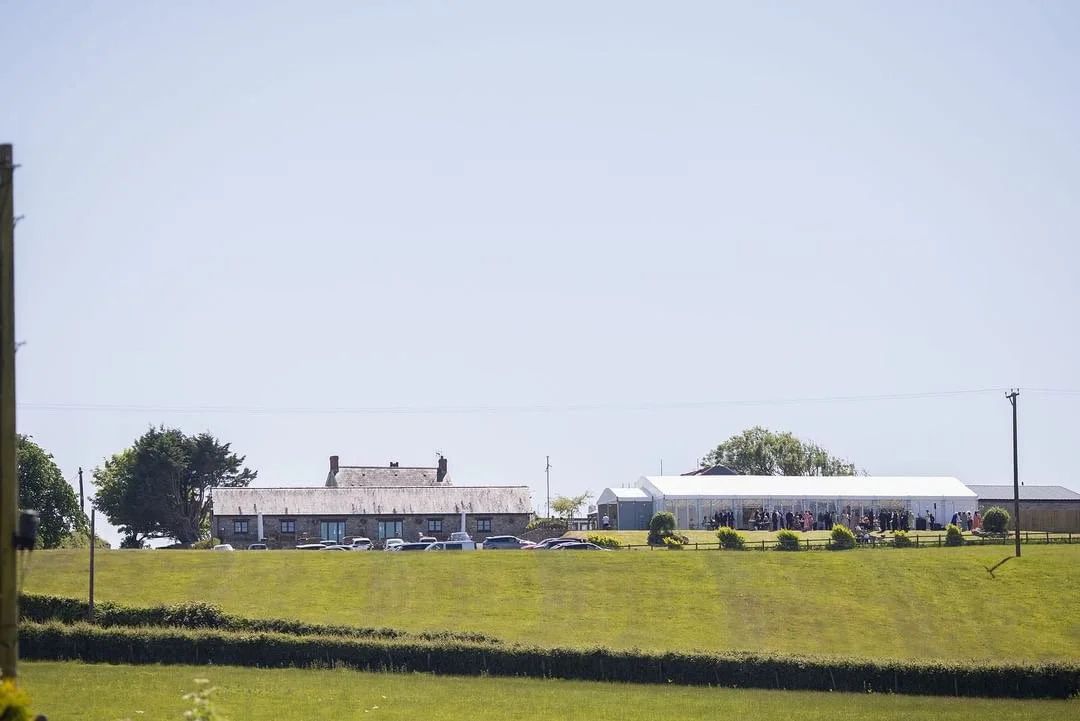 Countryside with a house and marquee on a hill