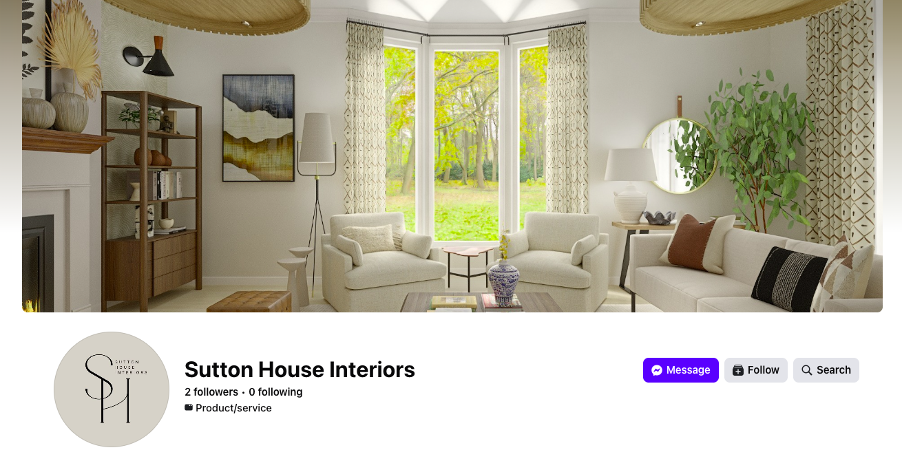 A cozy living room with white armchairs, a sofa, a wooden bookshelf, a fireplace, and large windows overlooking a green yard with trees, decorated with plants, lamps, and wall art.