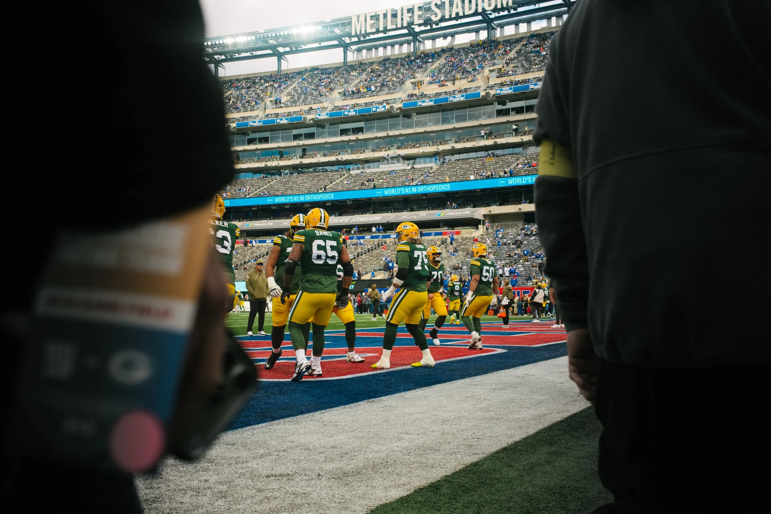 Green Bay Packers football players on the field during a game at MetLife Stadium.
