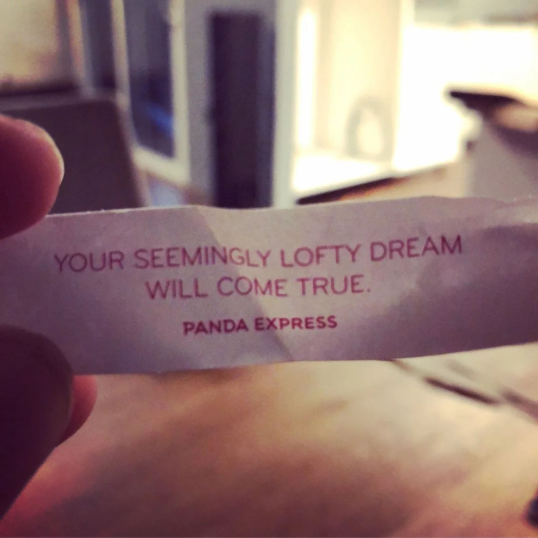 A small piece of paper with a motivational quote that says, 'Your seemingly lofty dream will come true.' The quote is attributed to Panda Express.