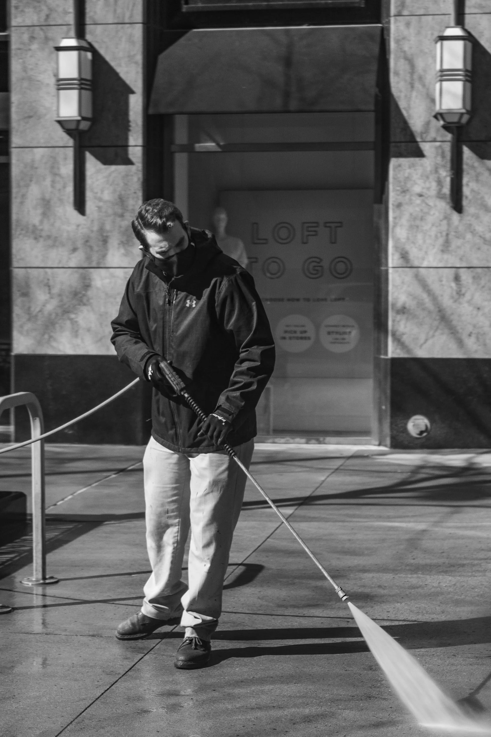 Man pressure washing concrete.