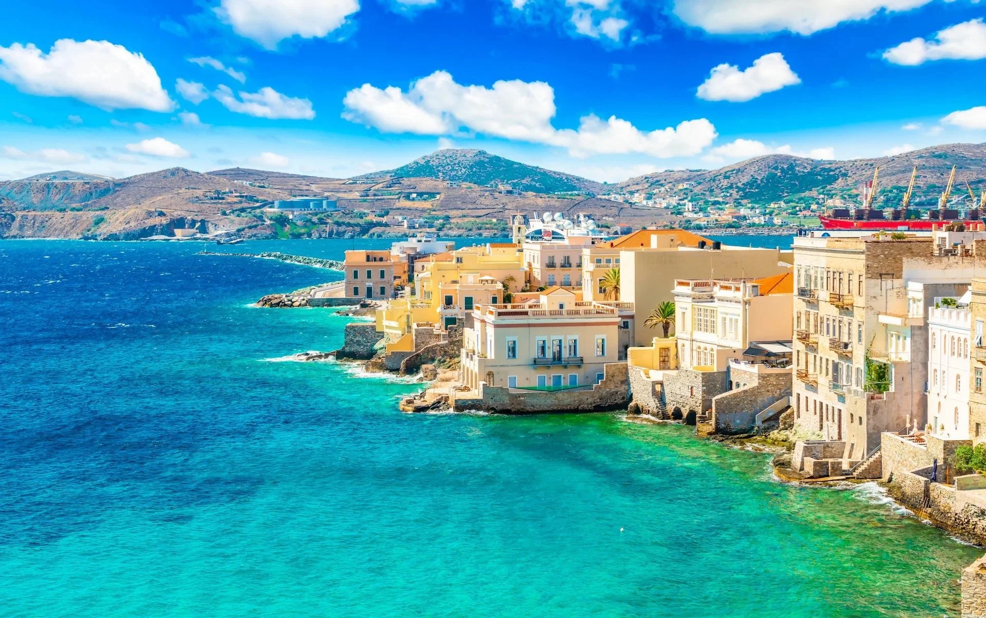 Syros waterfront with colorful neoclassical buildings and turquoise Aegean water