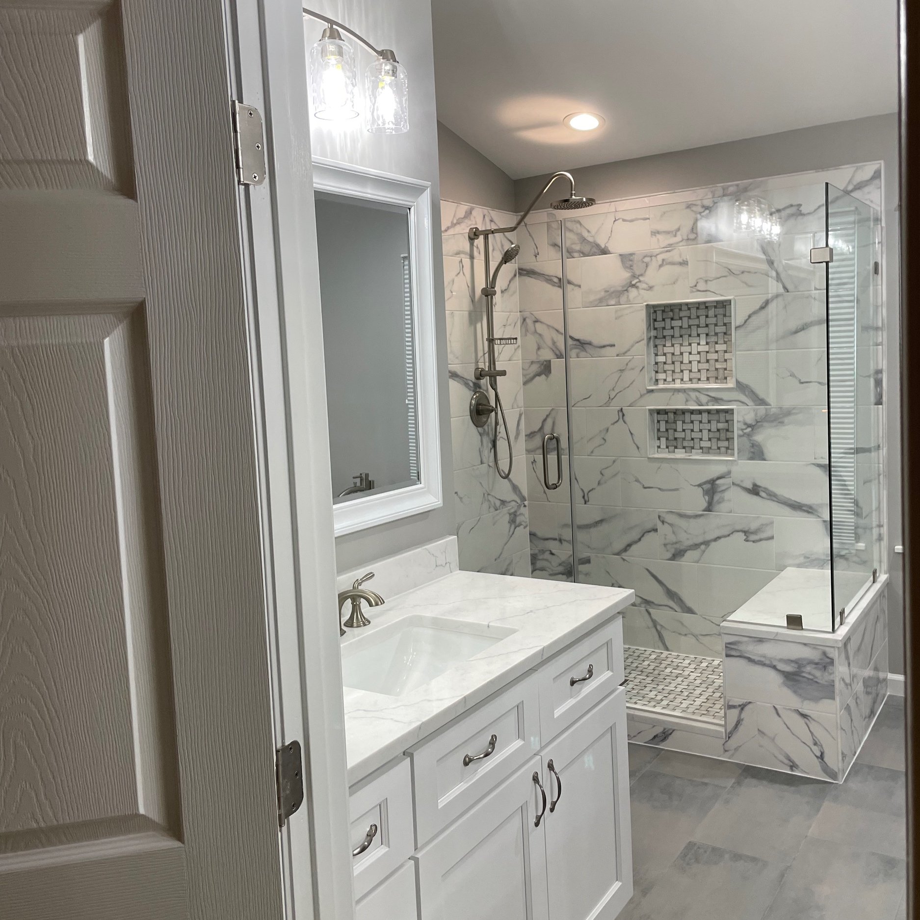 Luxurious shower with Kauai shower system and built in seat.