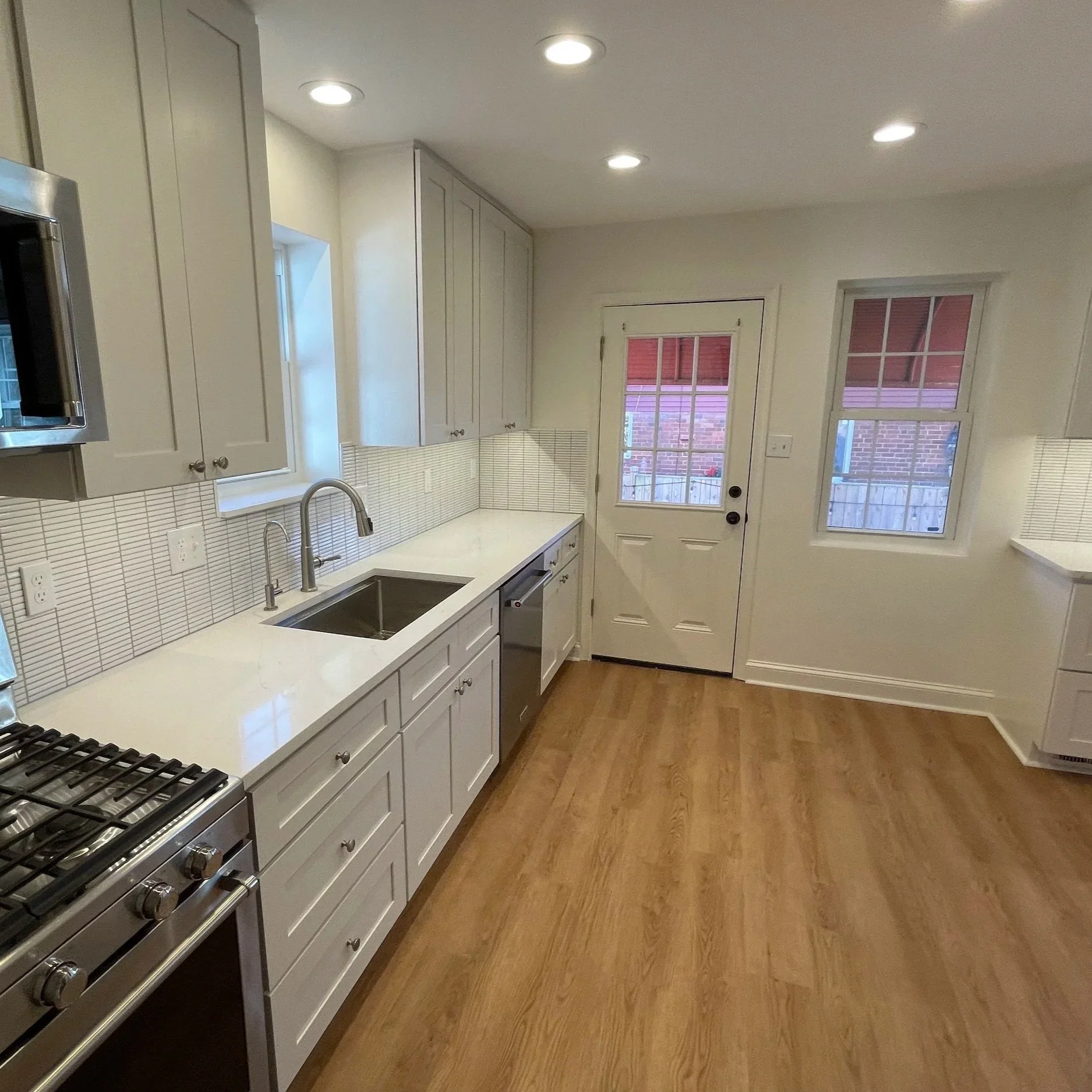 After: Photo shows taller cabinets made possible by soffit removal. Existing flooring replaced with LVT.