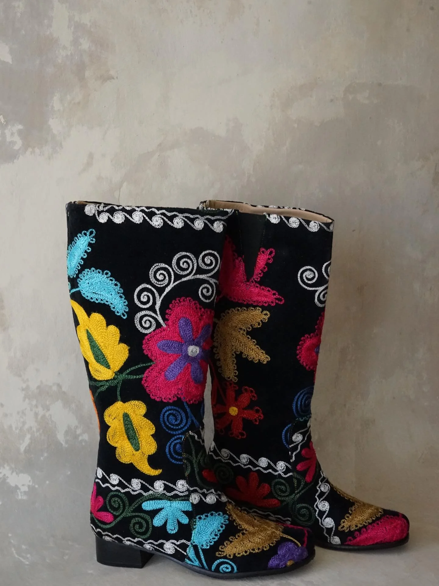Hand embroidered Suzani boots are a wardrobe essential for dark floral days, and the perfect transitional staple from Winter to Spring! Seen here are the Fergana Boots, named for Uzbekistan&rsquo;s Fergana Valley &mdash; an epicenter for textiles in 