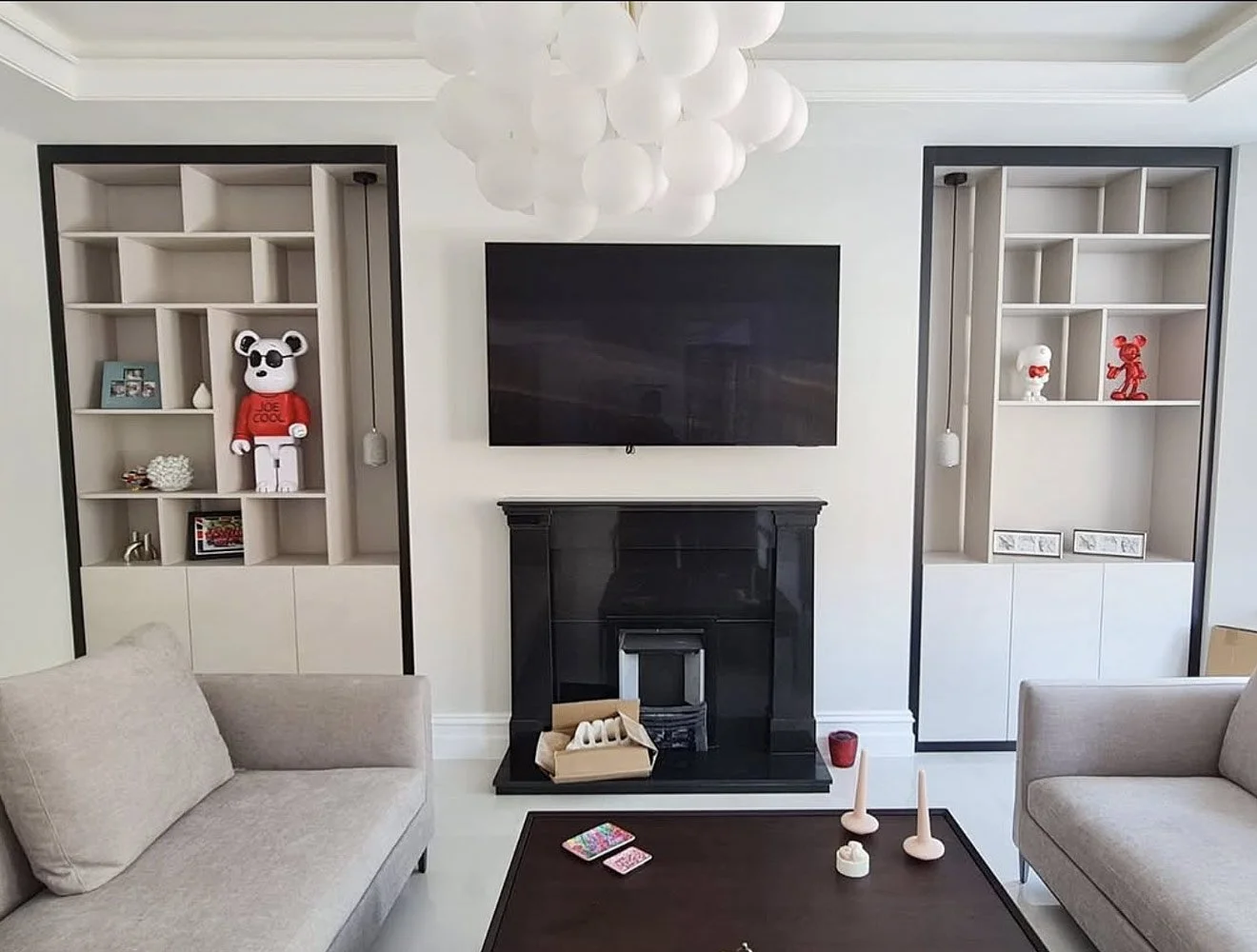 A bespoke living room display shelving installation featuring integrated LED lighting, fitted storage and contemporary alcove cabinetry.