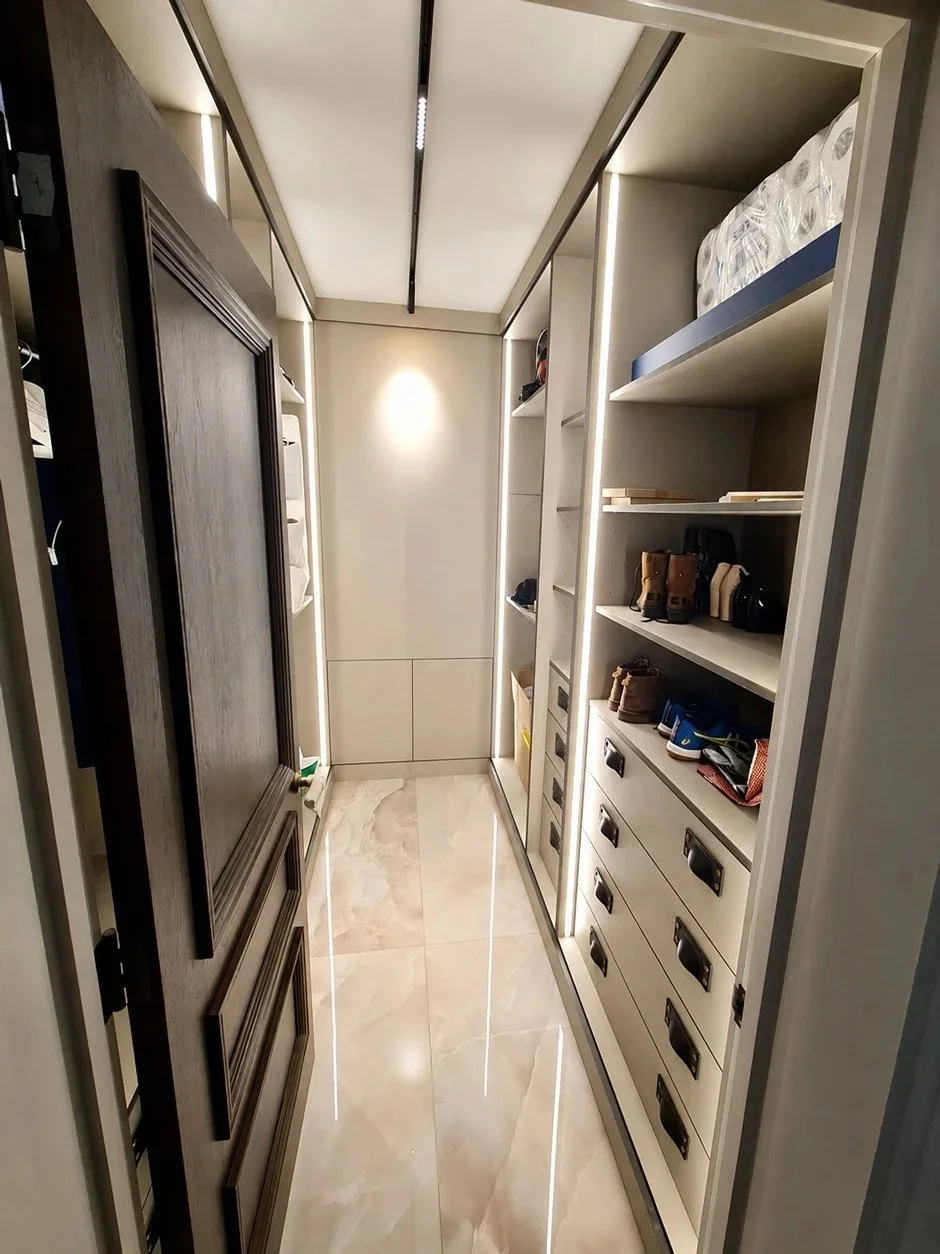 A made-to-measure walk-in wardrobe with fitted shelving, hanging rails, drawer storage and premium interior finishes.