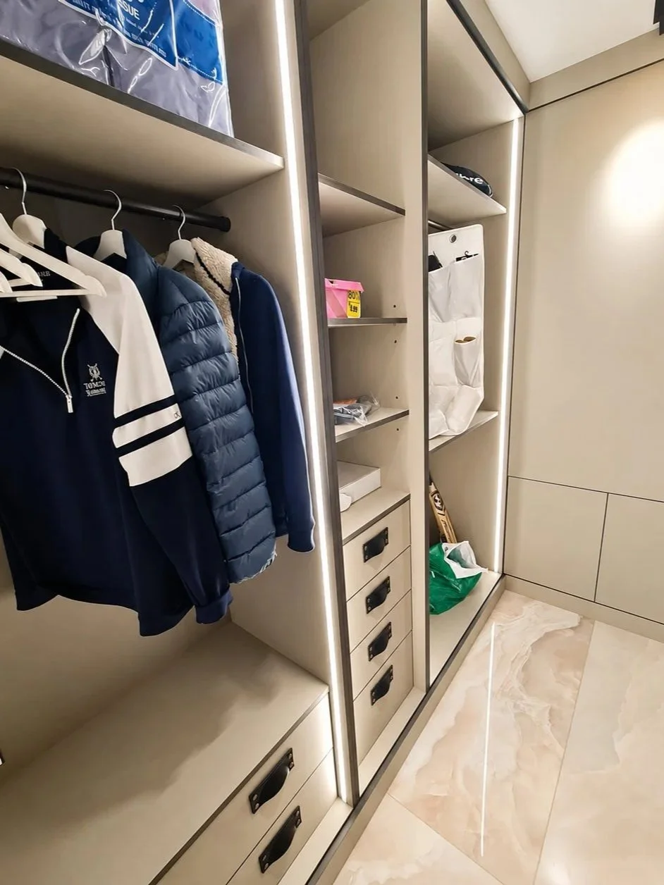 A bespoke walk-in wardrobe with illuminated shelving, fitted drawers and tailored storage designed for everyday organisation.