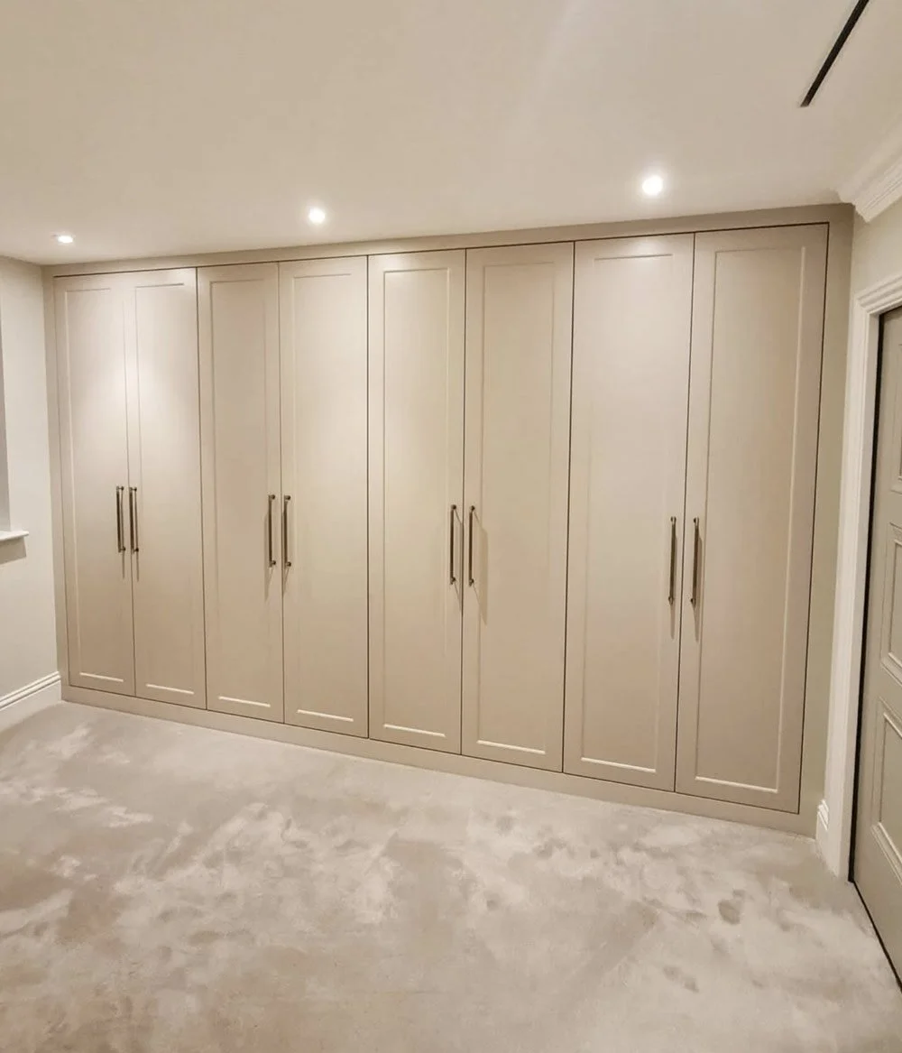 A bespoke bedroom furniture suite featuring full-height fitted wardrobes, integrated storage and a contemporary shaker-style finish.
