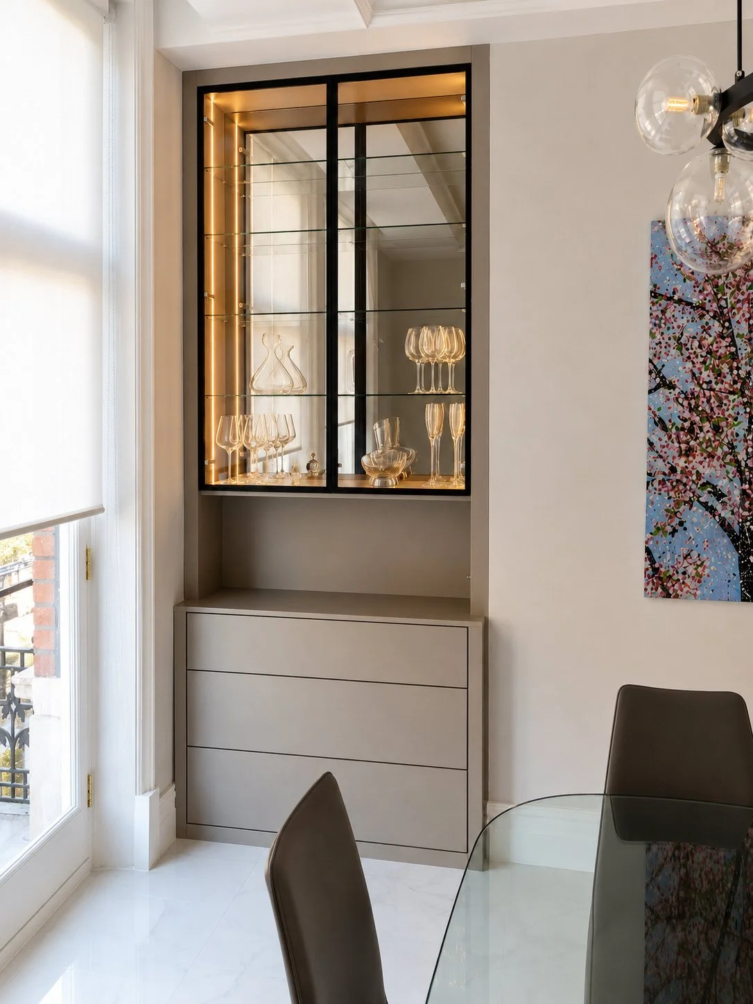 Custom dining room display cabinets combining illuminated glass shelving, concealed storage and premium fitted furniture design.
