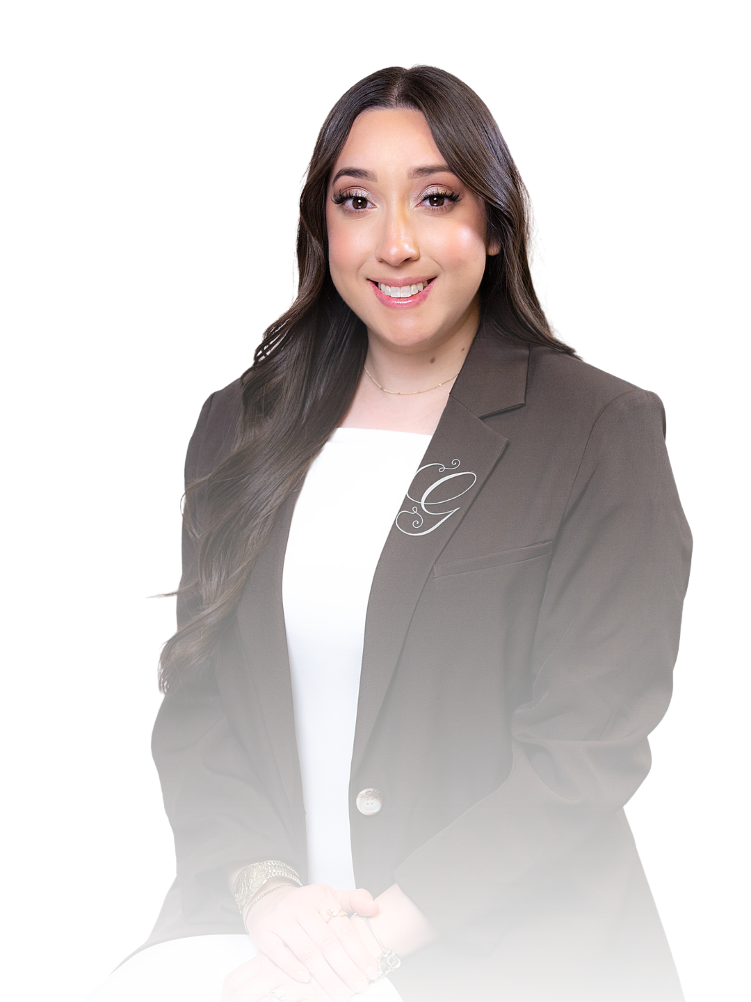 A woman with long dark hair, wearing a dark blazer and smiling, holding a microphone, against a white background.