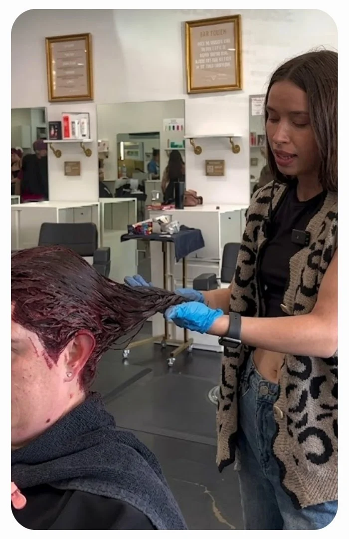Professional hairstylist custom mixing hair color formulas at a salon color bar station