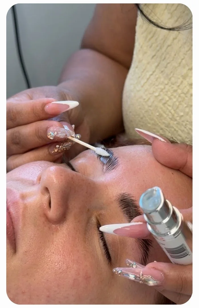 Beauty technician applying lash lift solution during a professional eyelash treatment