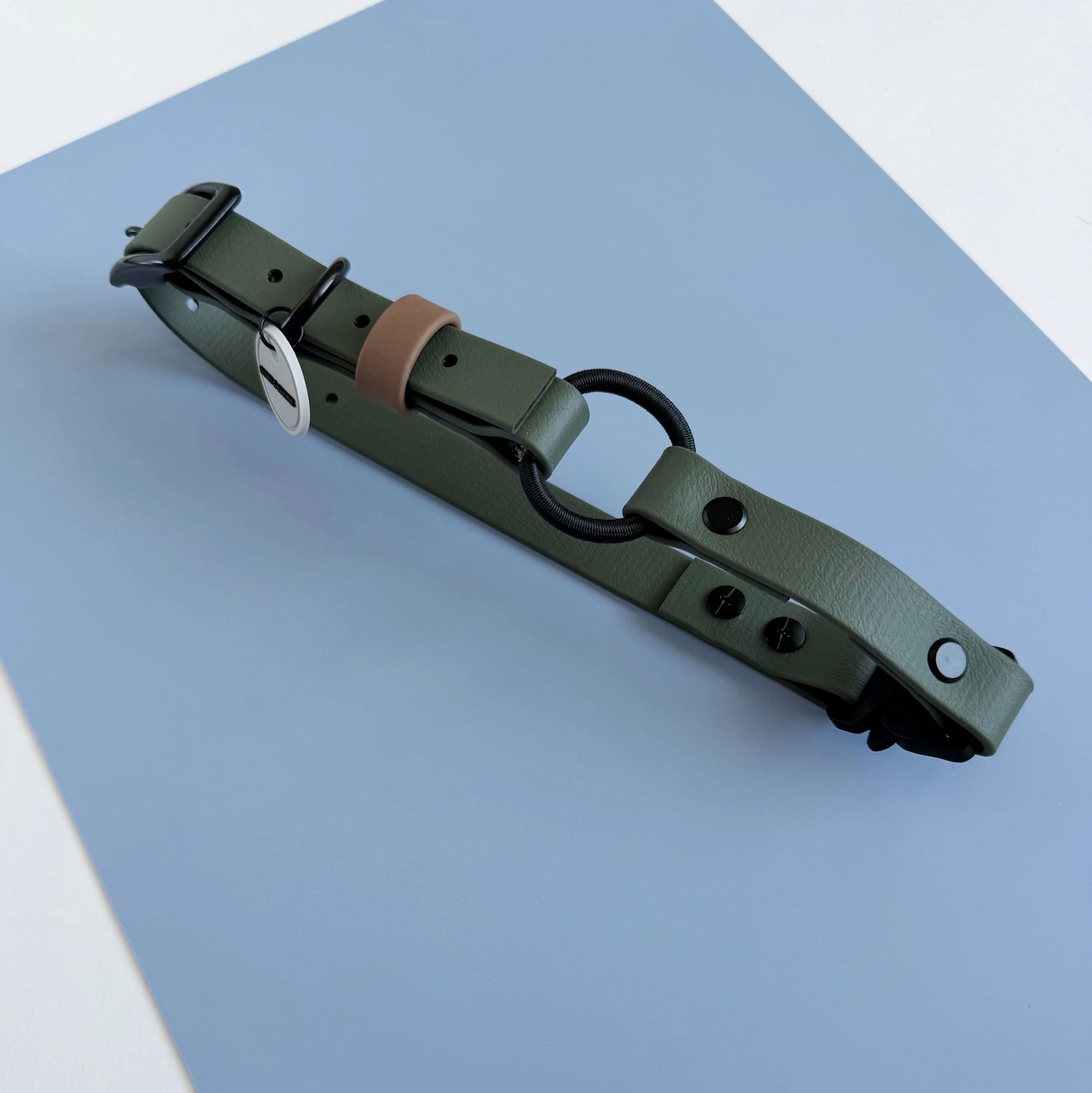 Olive and black biothane quick-release e-collar strap with integrated bungee and mounted GPS tracker