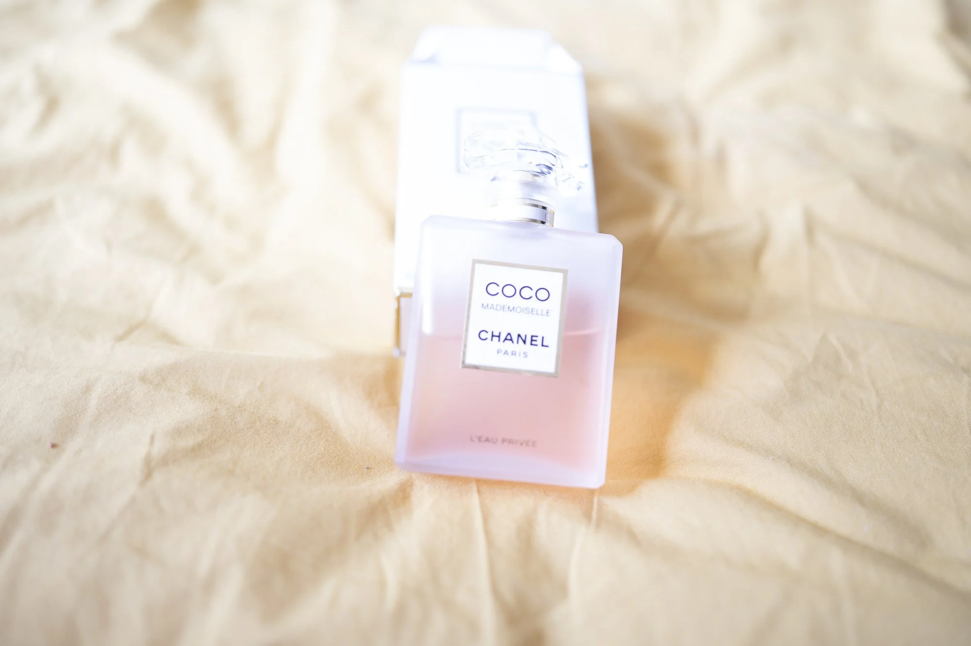 Flacon de parfum Chanel Coco Mademoiselle sur une surface beige