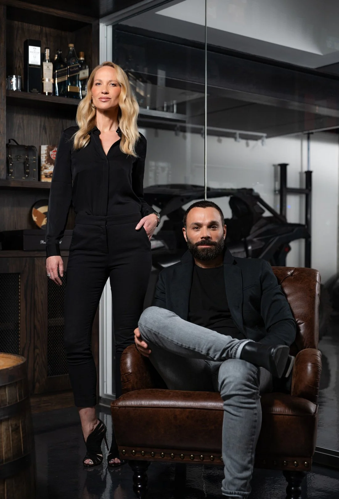 The Stamp & Hammer architects, Mitch sitting and Berit standing inside the garage of the Meadow Wood residential architectural project in Mississauga, Ontario