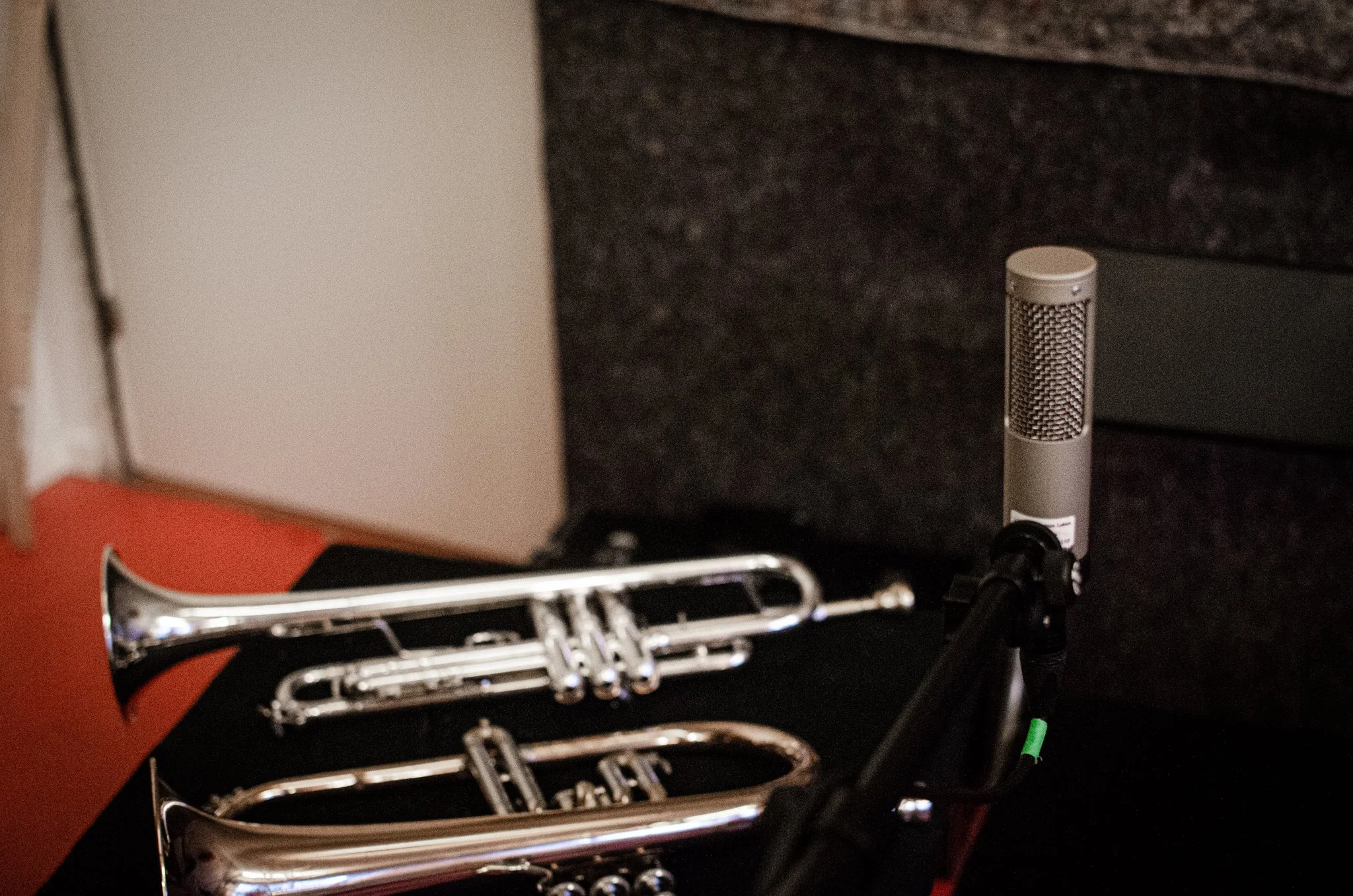 Sovende trompetter og et mikrofon i et rom for musikkøving.