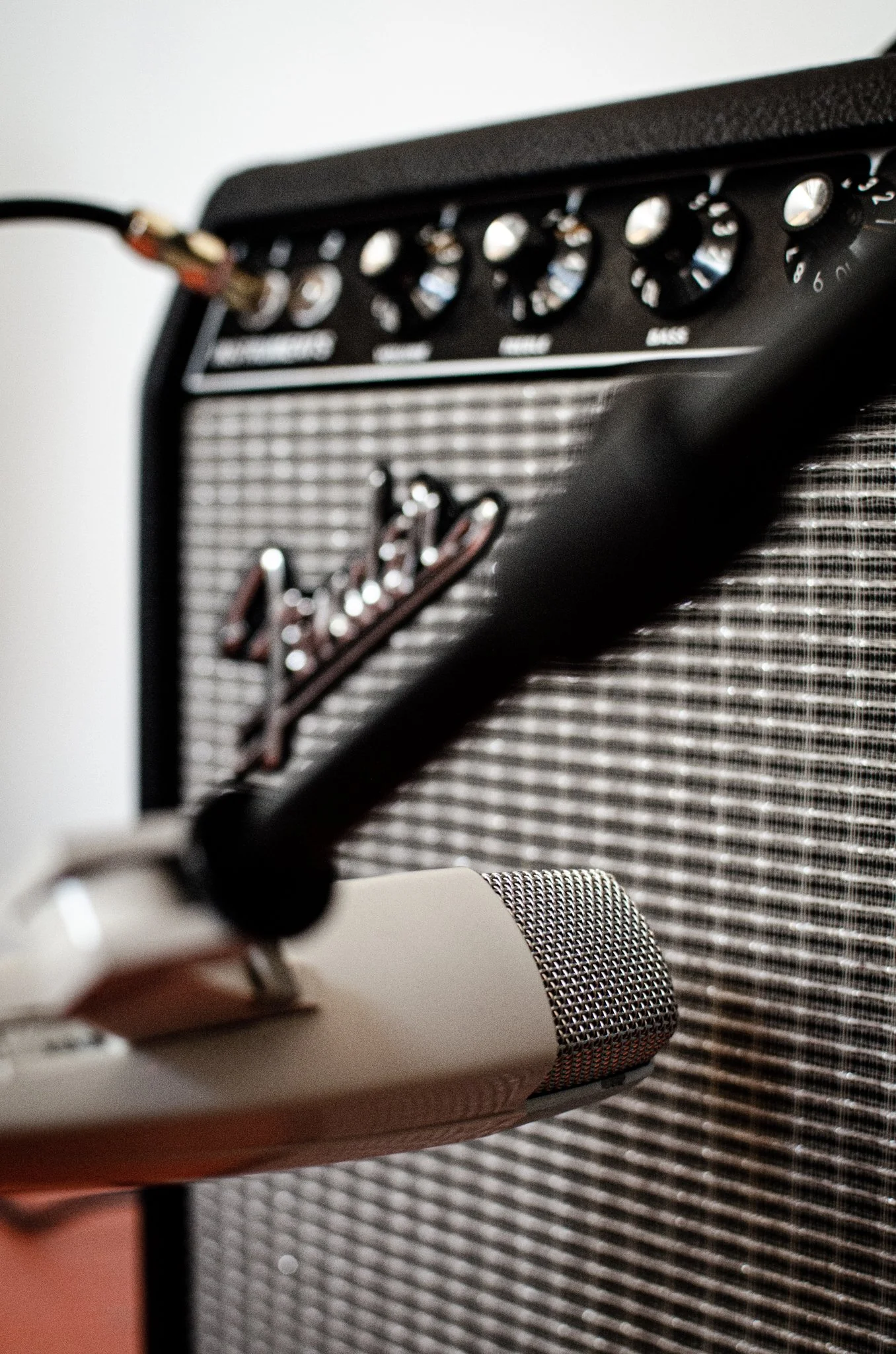 Nærbilde av en mikrofon foran en Fender forsterker.