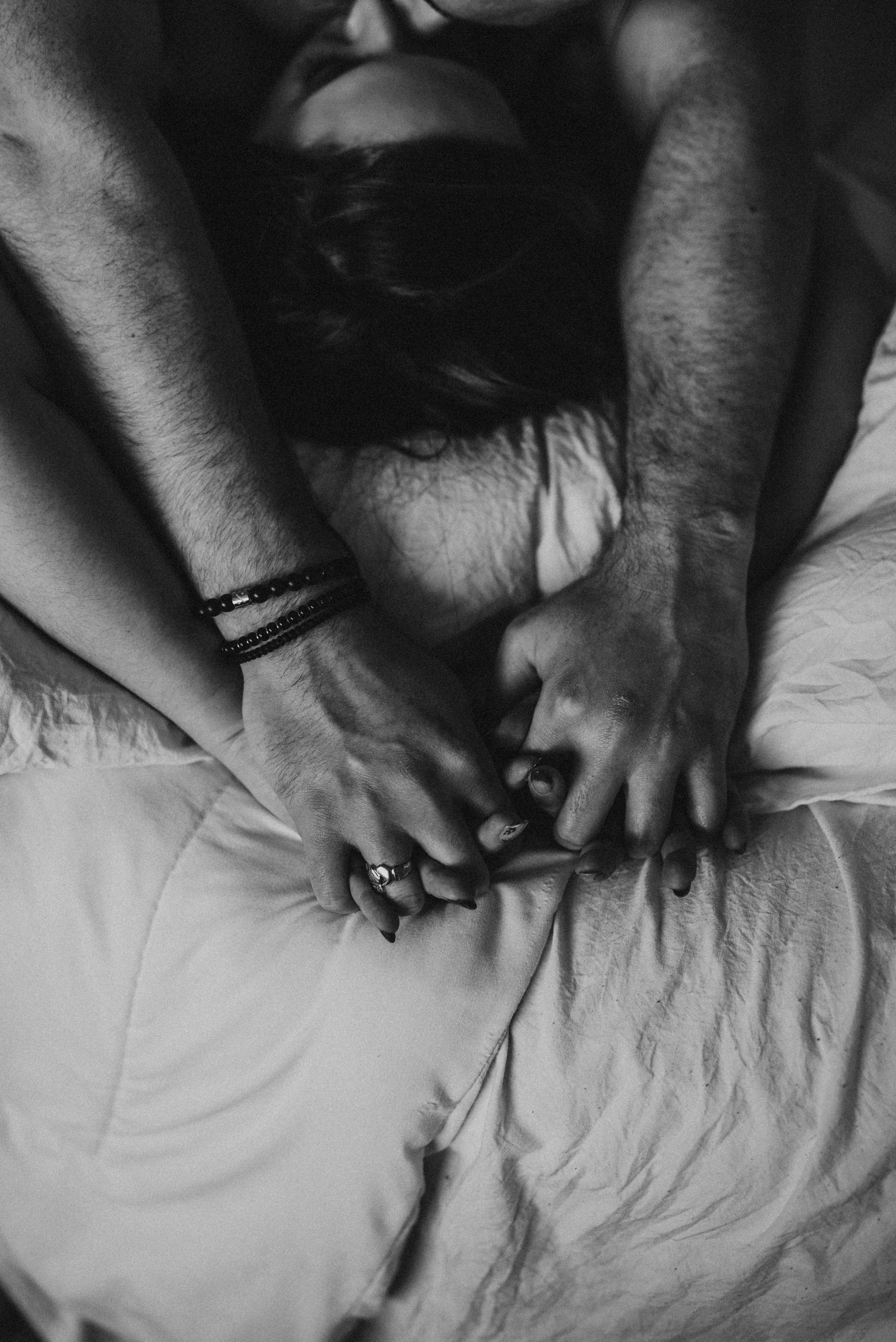 Couple holding hands in affectionate embrace, black and white.