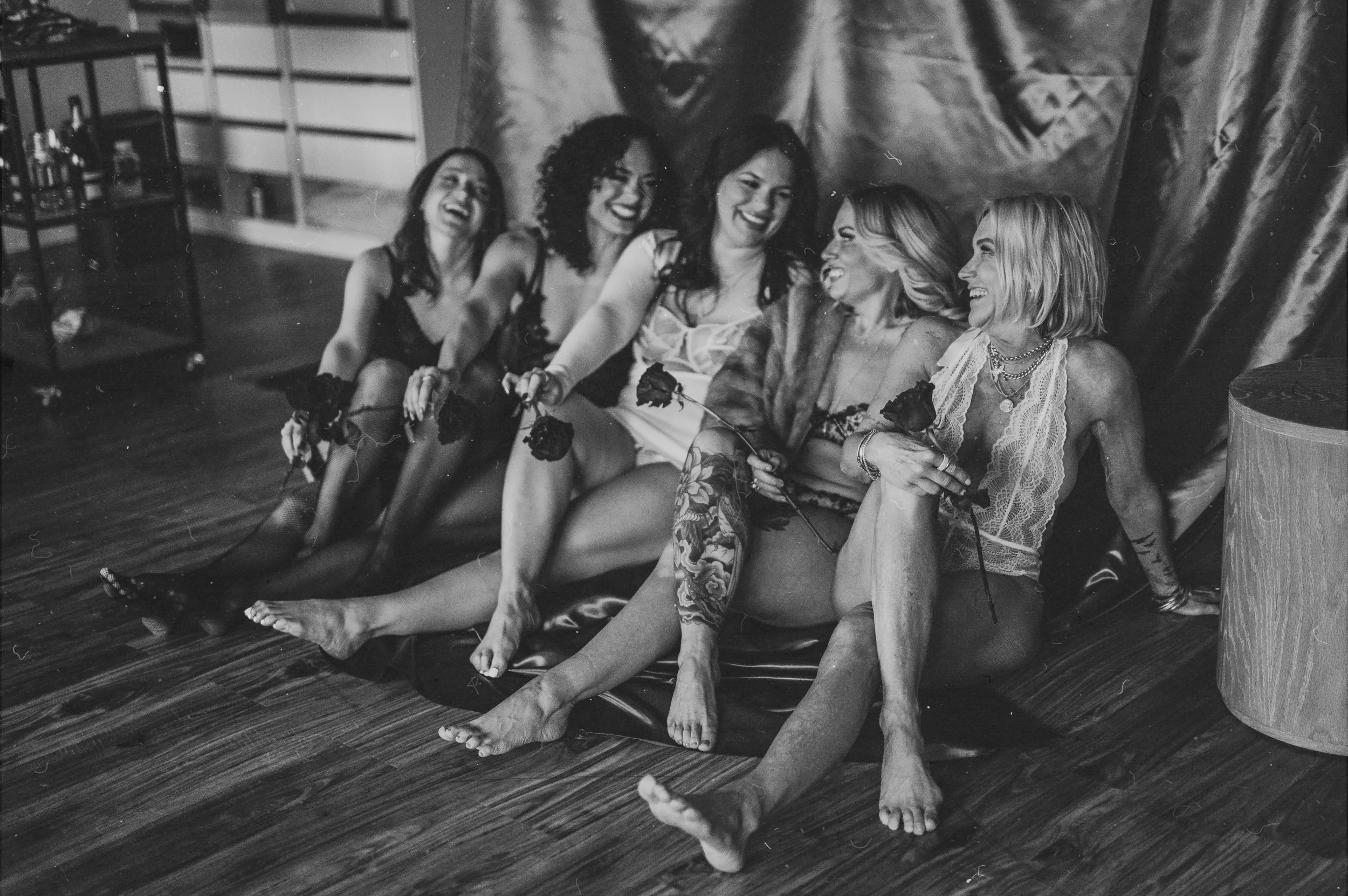 group of women sit on the floor of a Dover studio giggling
