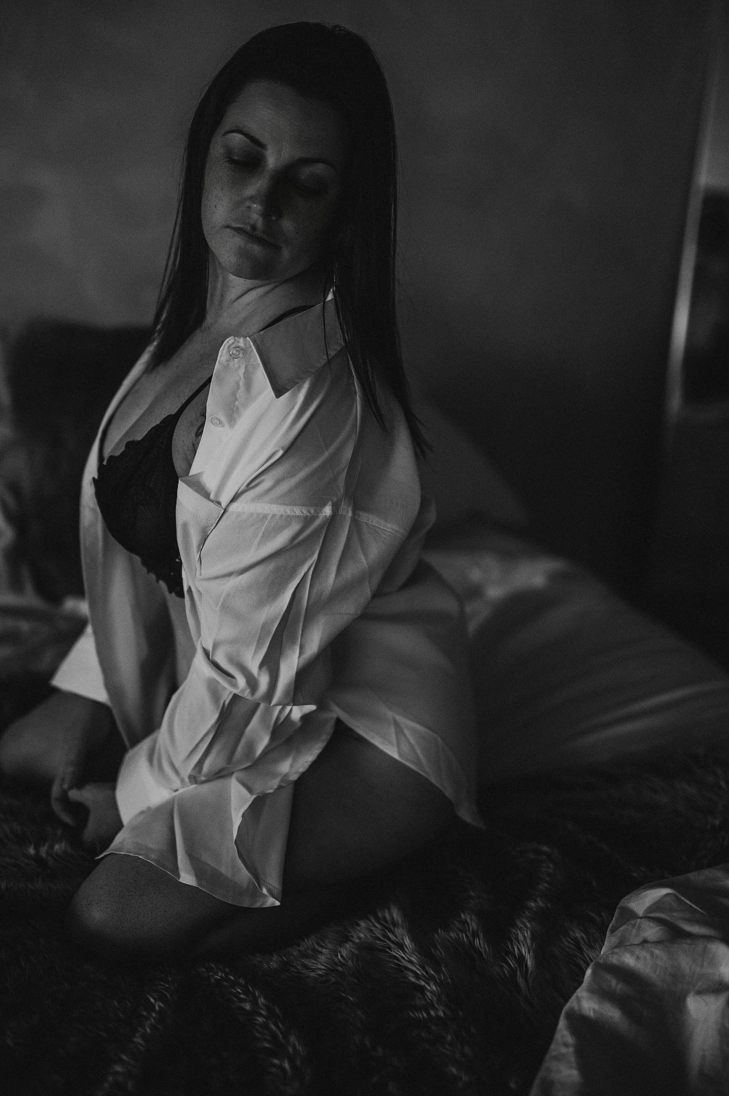  model in black lingerie with white button down on bed for empowering session 