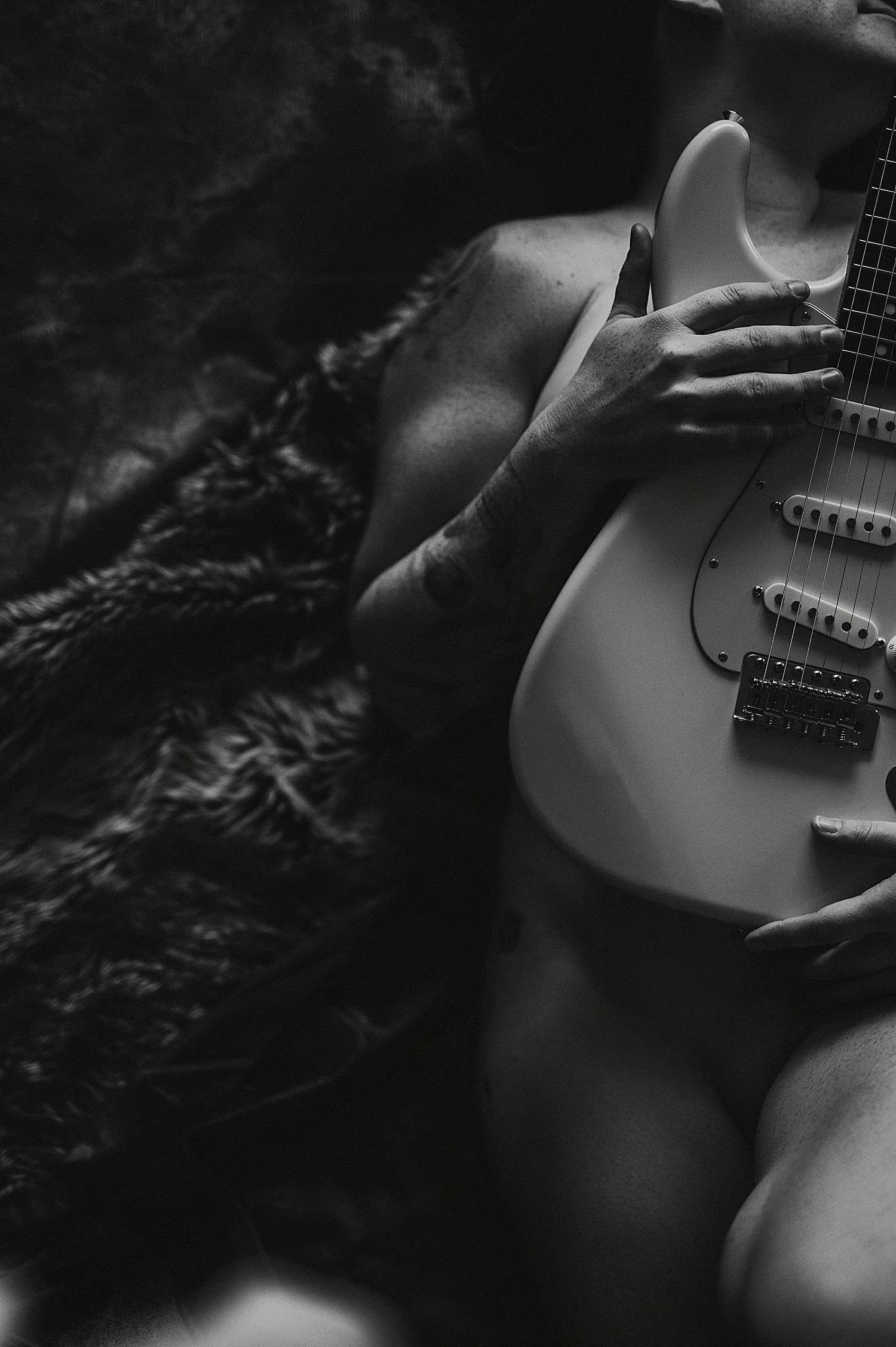  person covers herself with electric guitar on floor by New Hampshire Boudoir Photographer 
