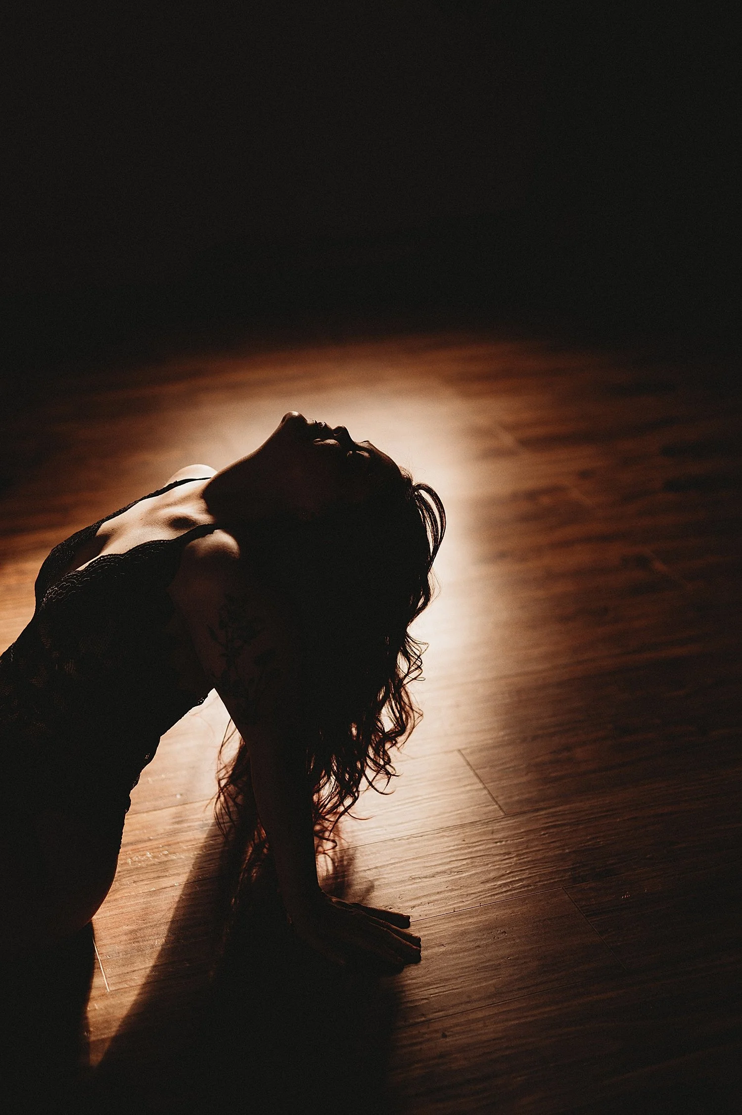  person’s silhouette as she sits on the floor and leans back by Hannah Mac Studios 