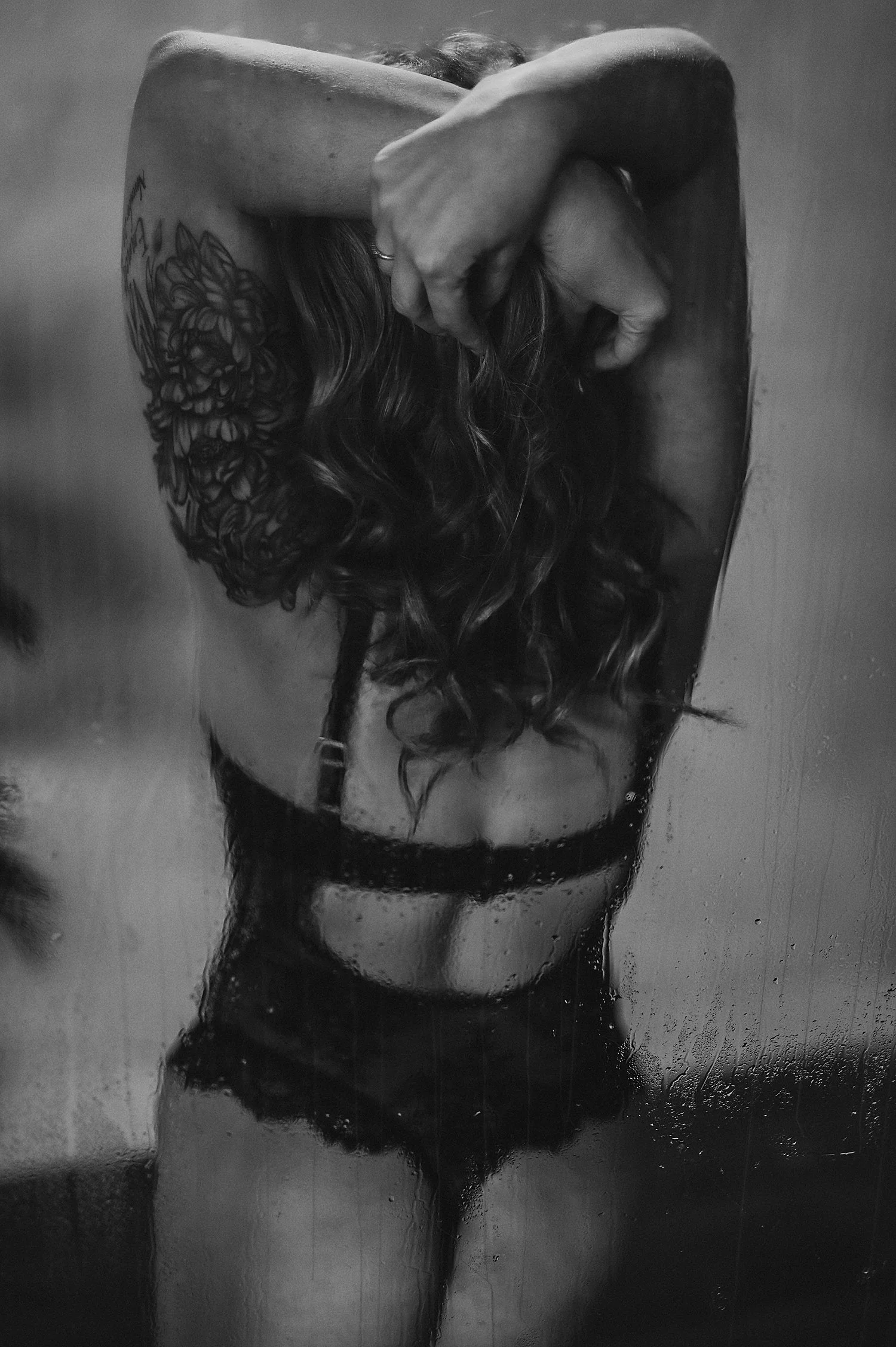  woman leans her arms overhead behind shower wall at Hannah Mac Studios  