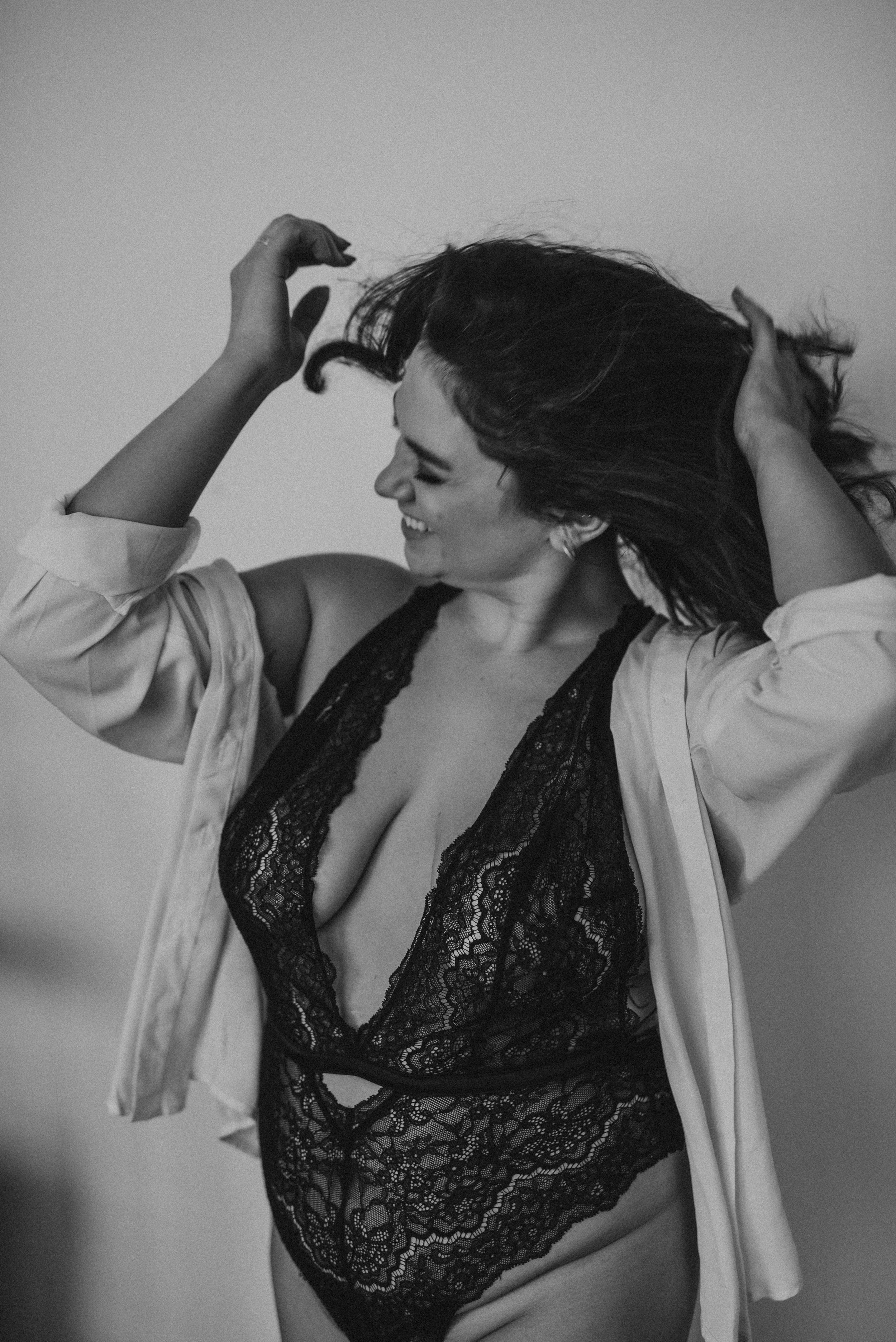 Woman in black lace lingerie and white shirt posing.