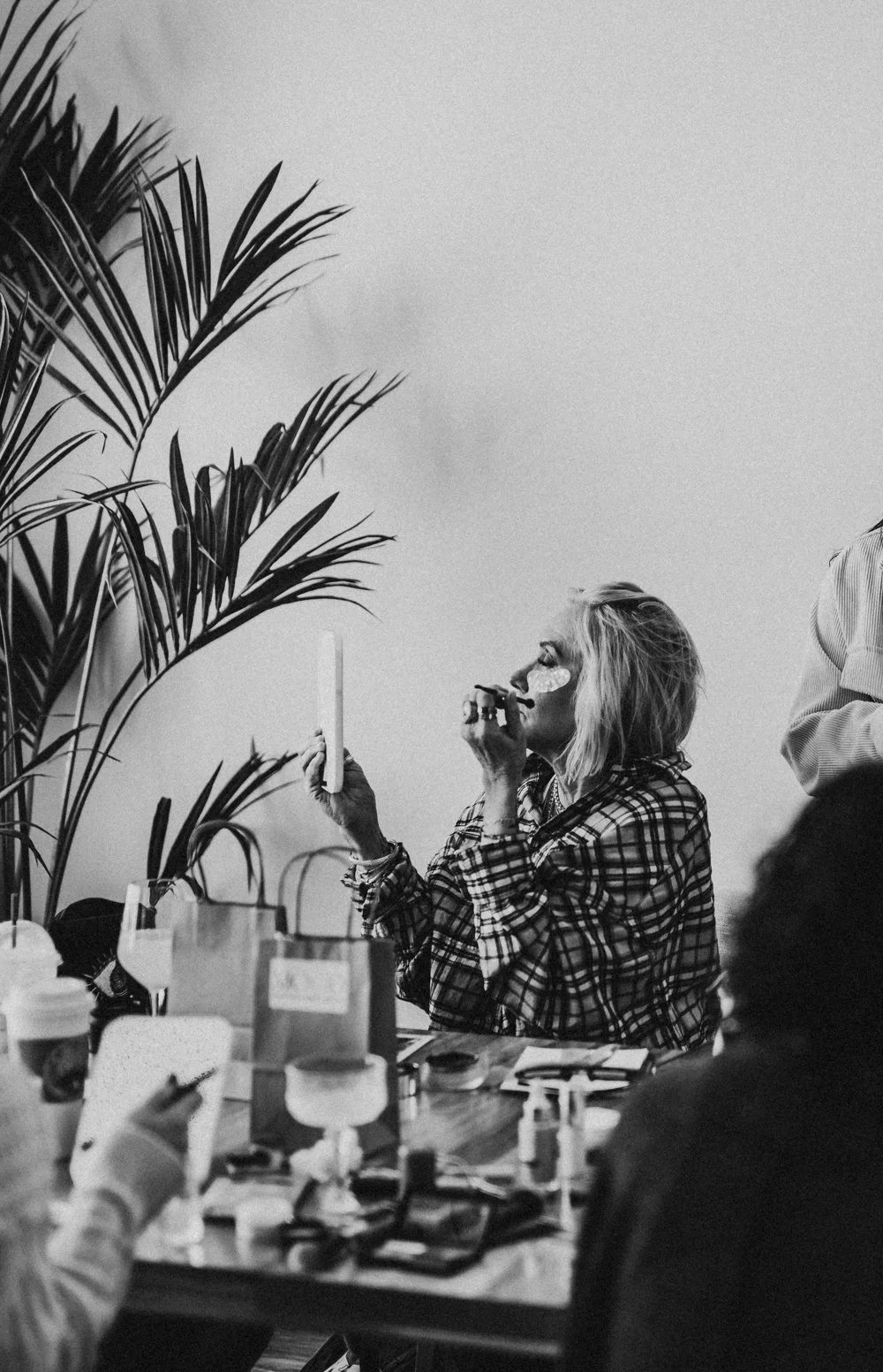 woman looks in the mirror at table by New Hampshire boudoir photographer