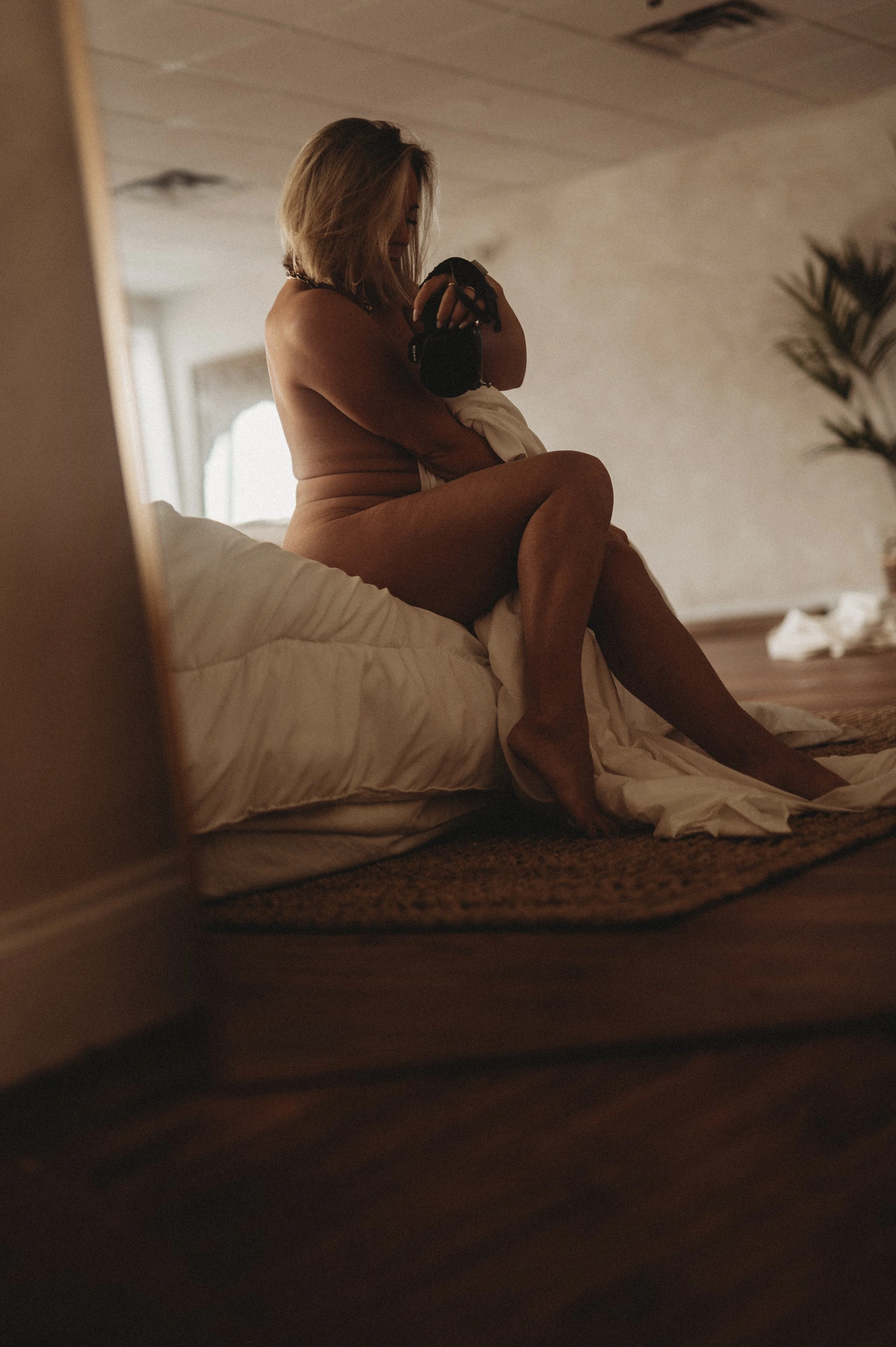 nude woman on bed with sheet by Hannah Mac Studios