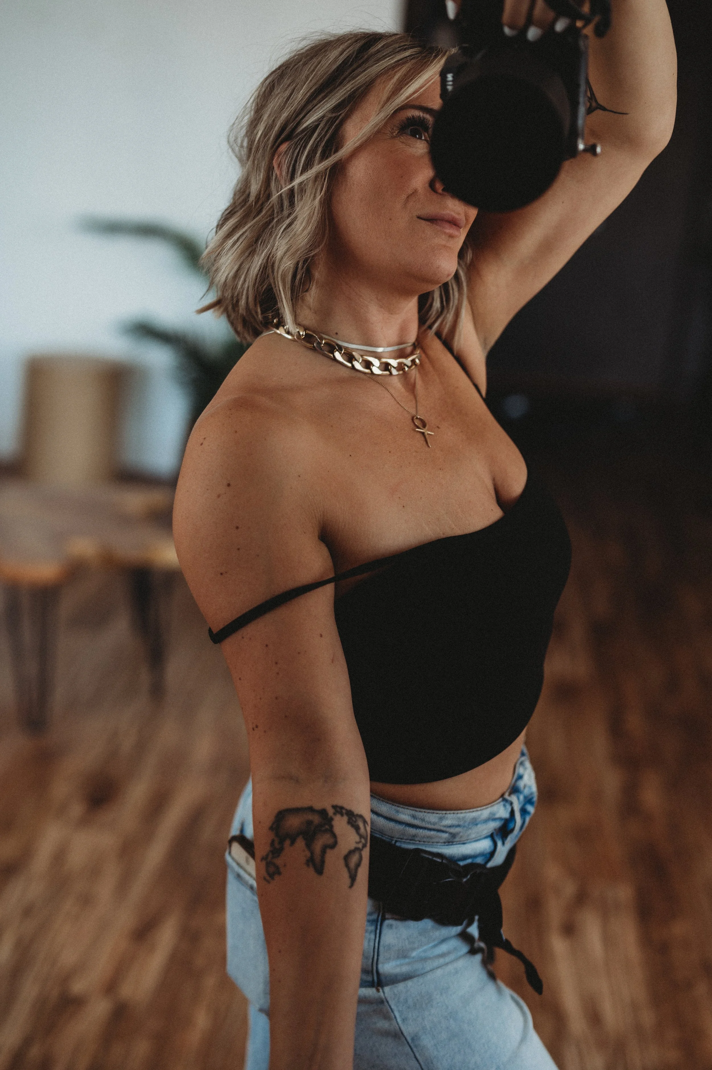 blonde in tank holds up camera for empowering session