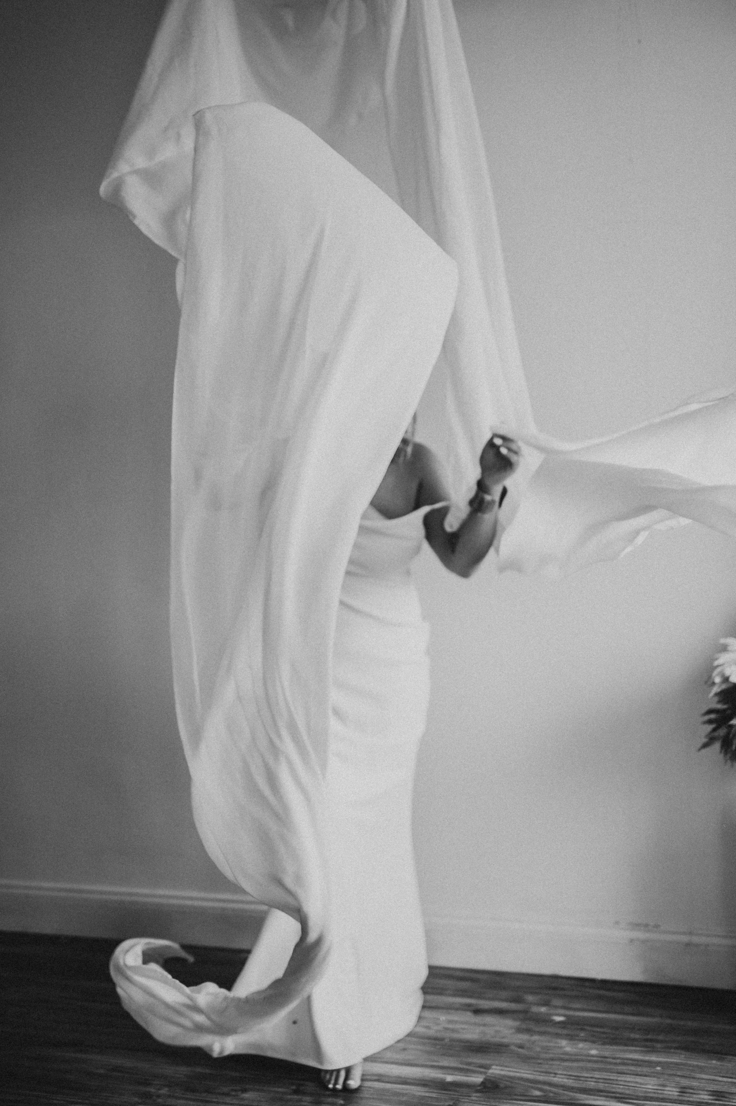 person throwing large white sheets around for empowering session