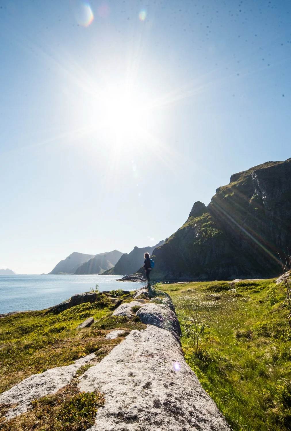 woman stands on old ruin overlooking sea by Hannah Mac Studios