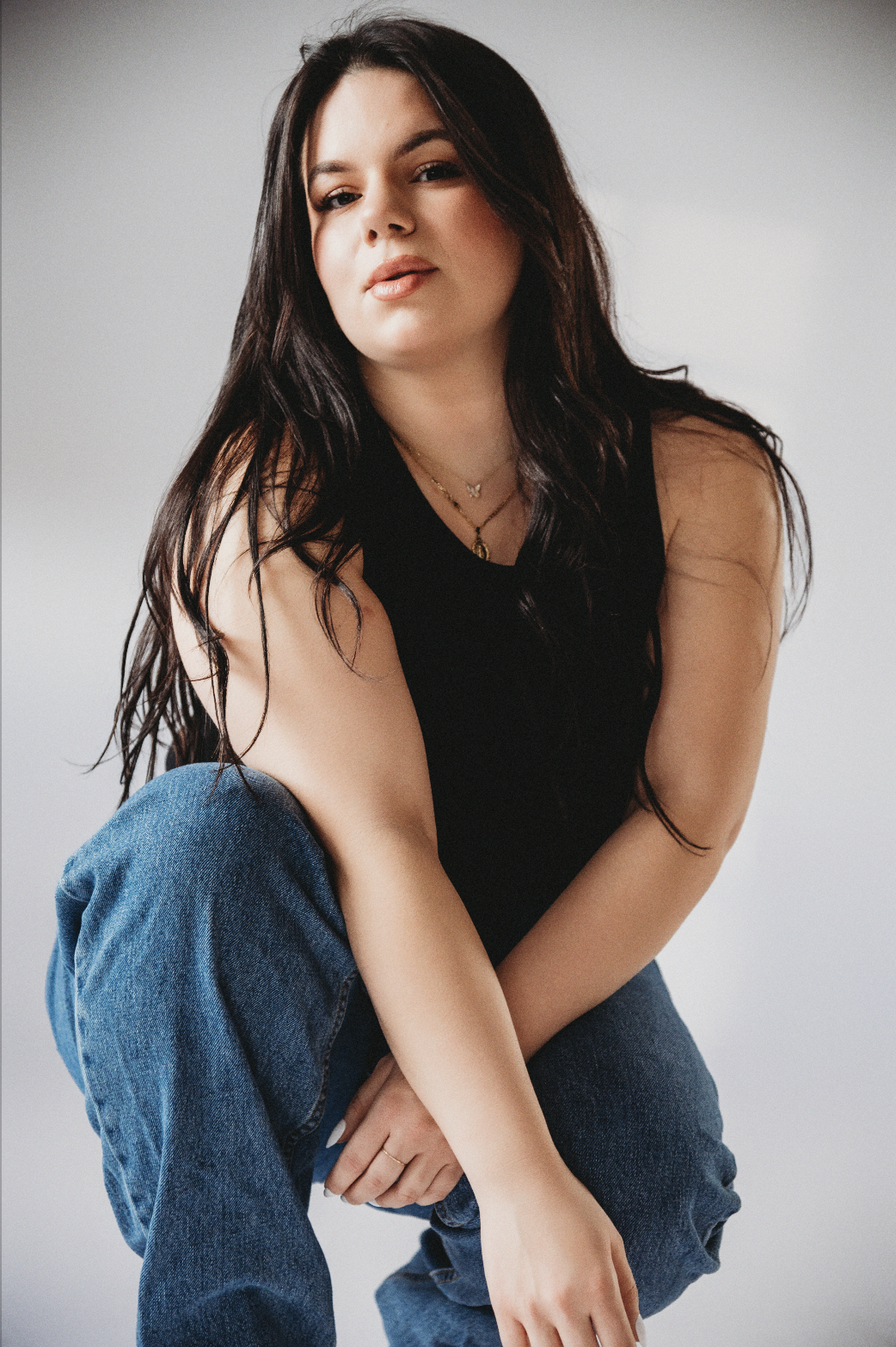 curvy woman in jeans and black tank at Hannah Mac Studios
