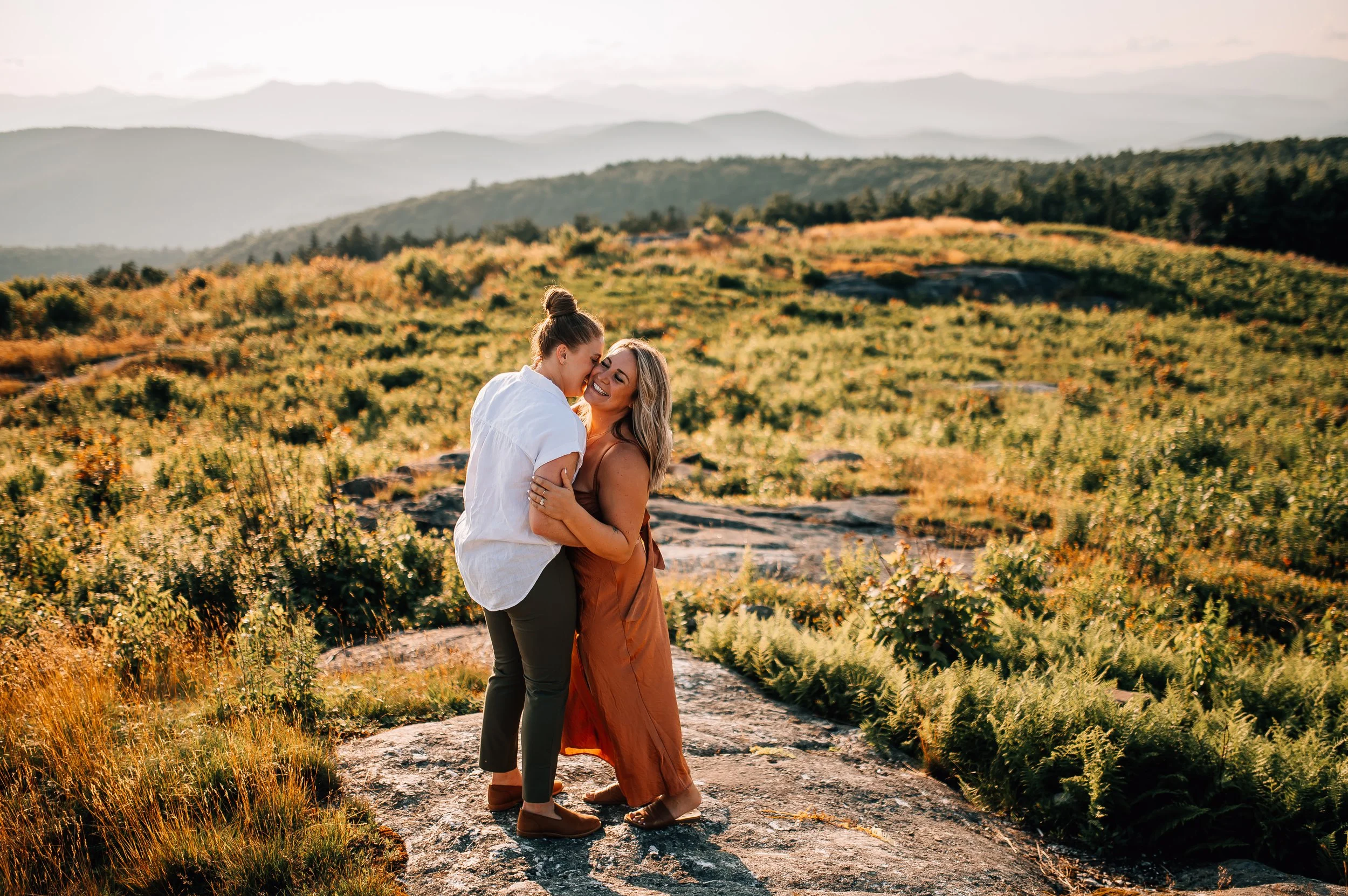 gay couple embraces in beautiful landscape by Hannah Mac Studios